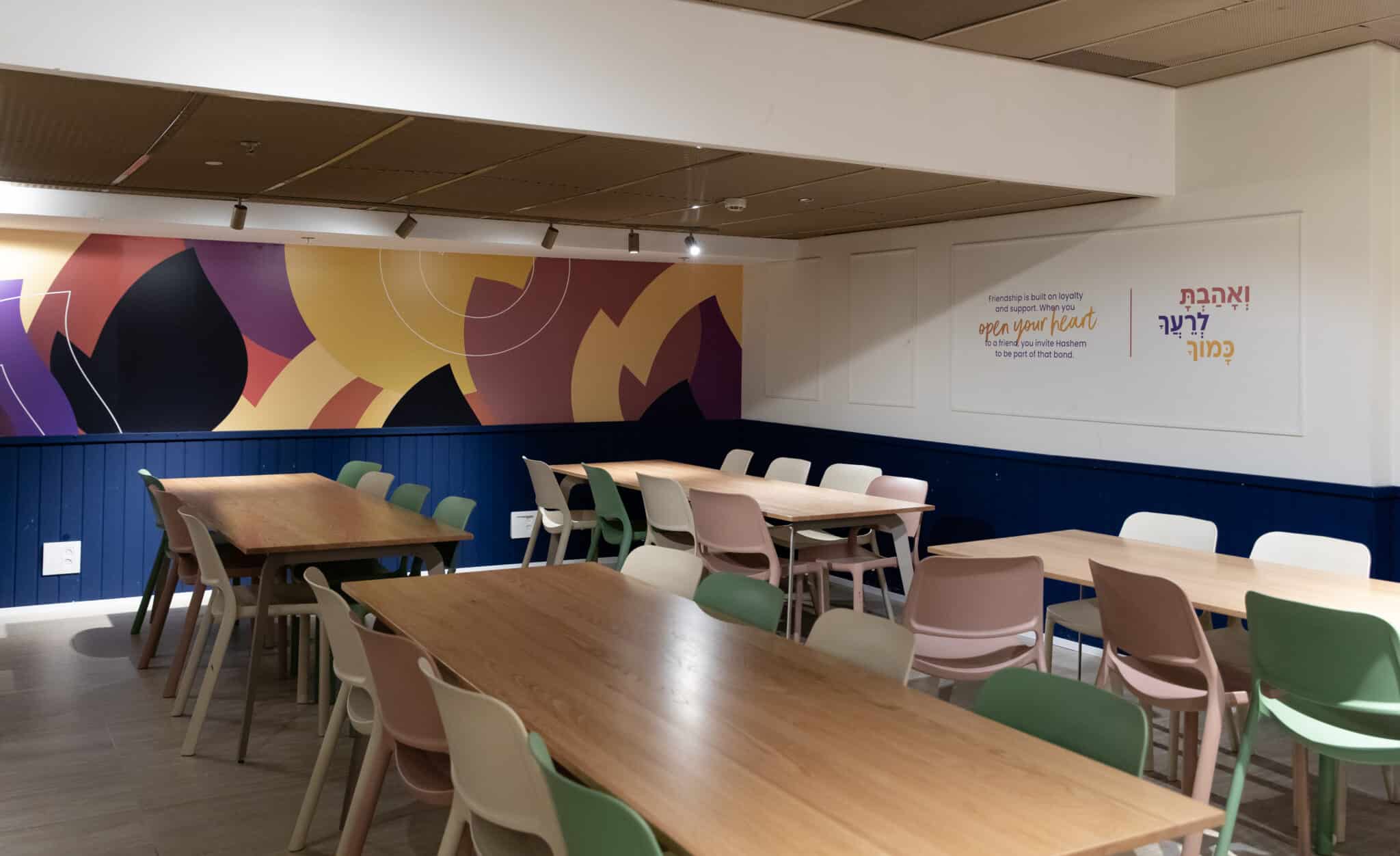 Abstract wall graphic and a Hebrew quote in the dining hall