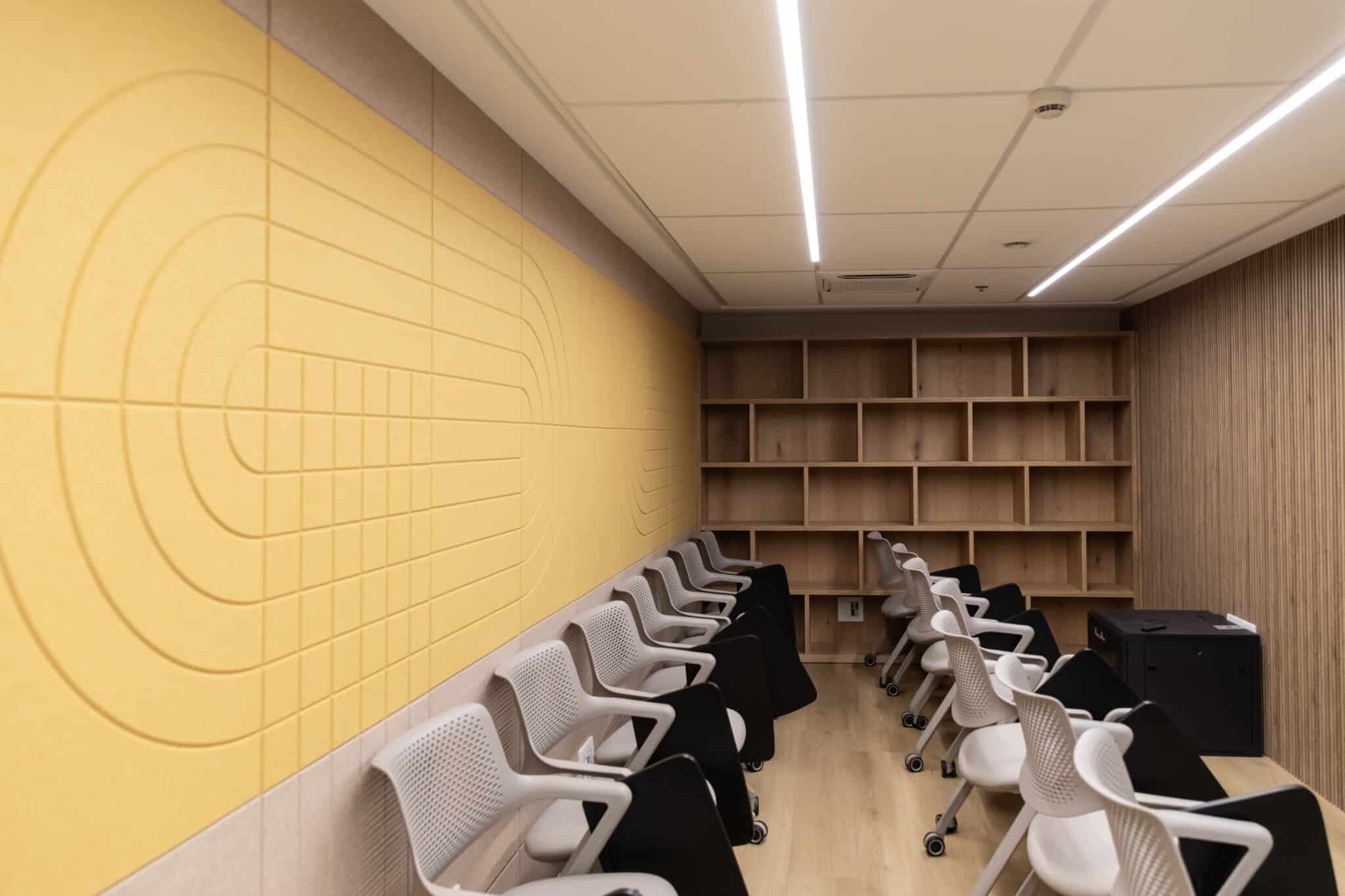 Yellow acoustic panel wall with concentric arcs in a lecture room