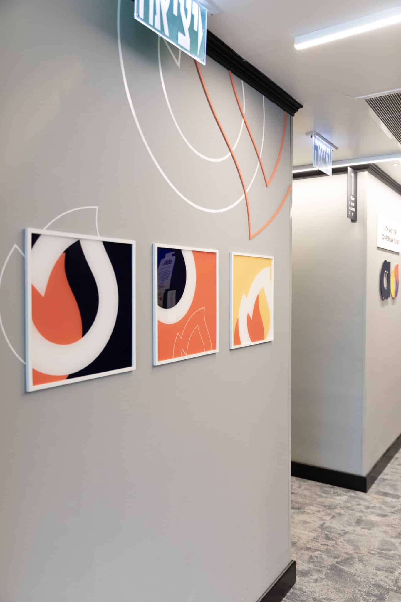 Three framed abstract prints on a wall with printed arc lines