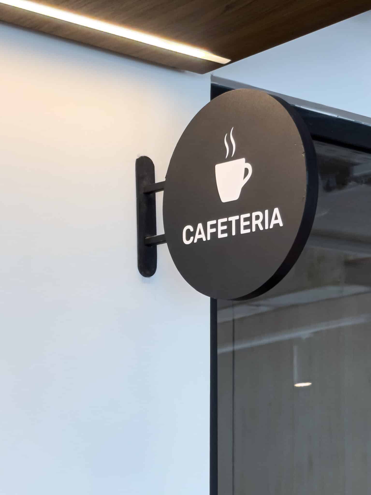 Round cafeteria flag sign projecting beside a glass wall