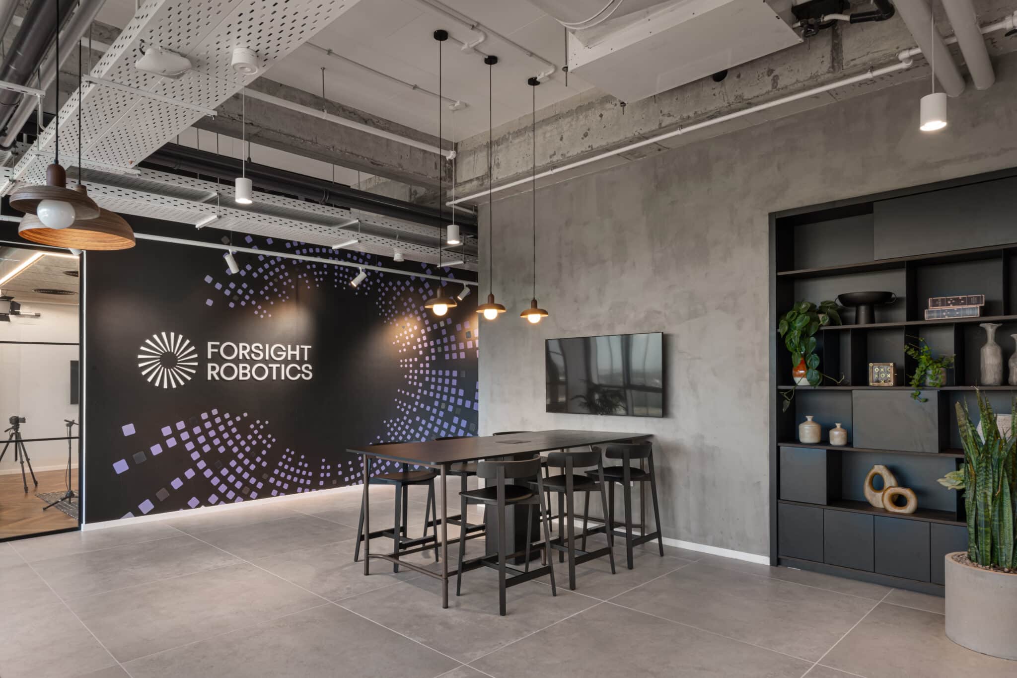 Brand logo on a dark wall of purple squares above high tables