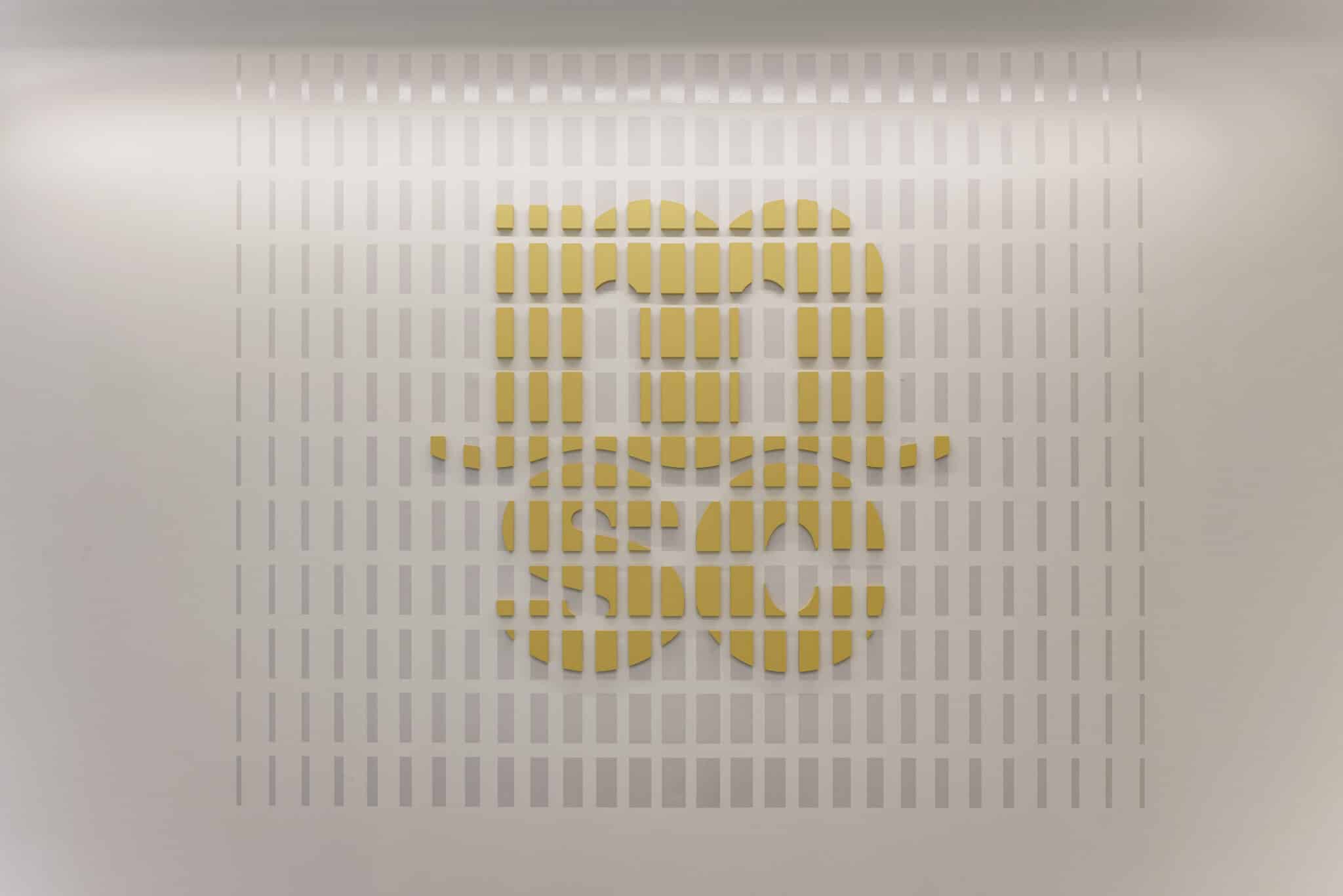 Close-up of a bar built logo in yellow on a pale wall