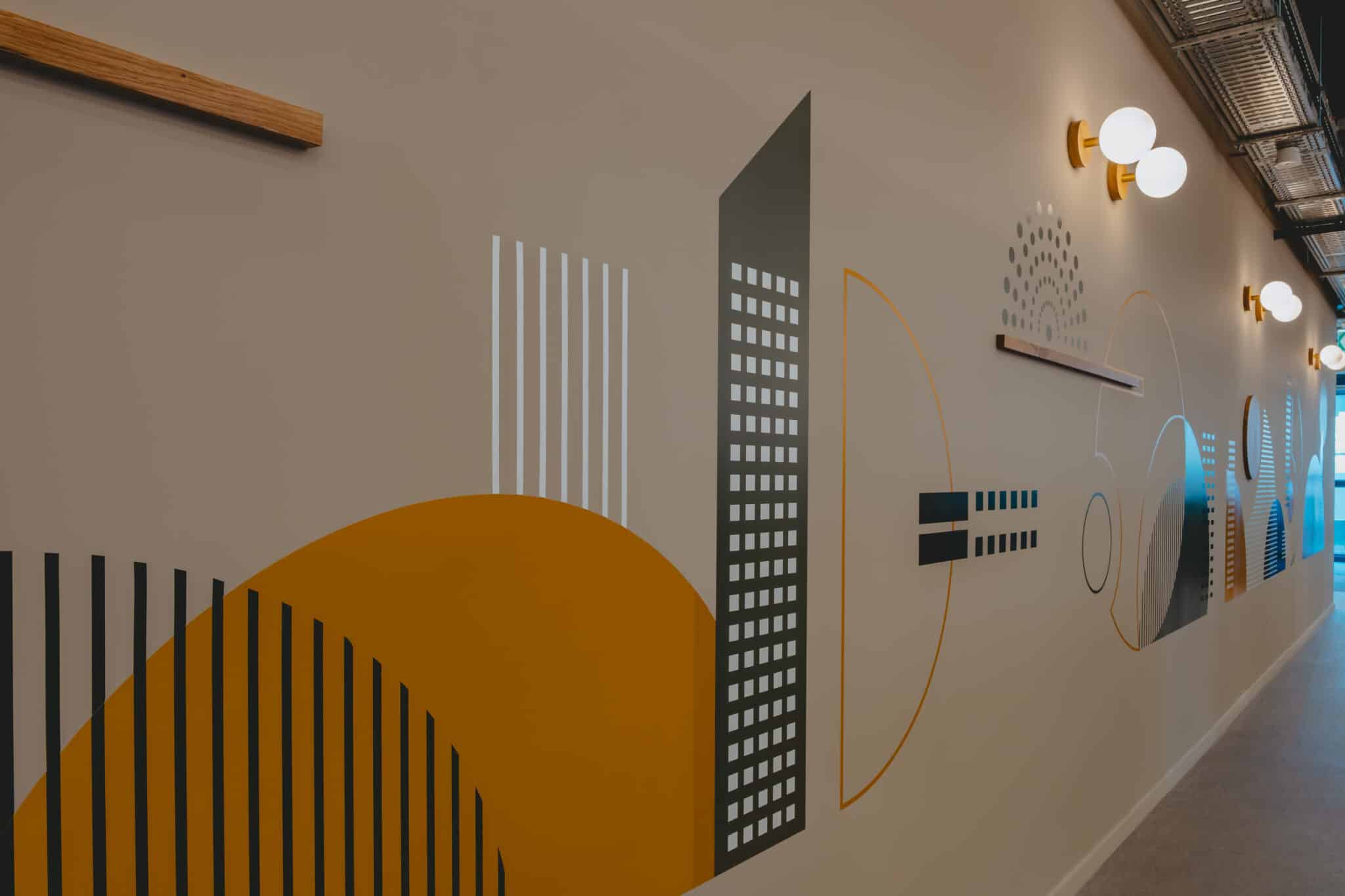 Wall graphic of a city skyline in orange and grey with wood elements