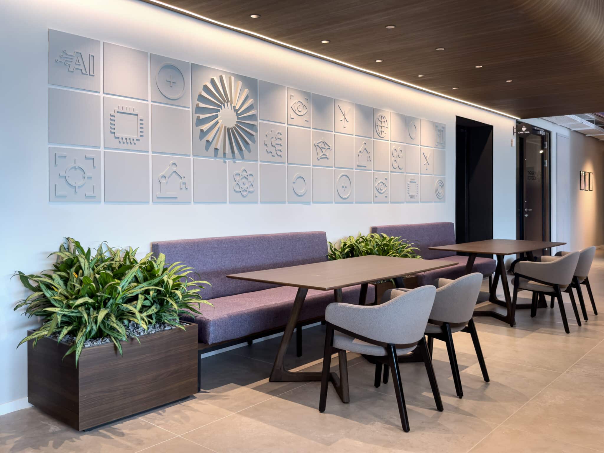 Relief tiles with technology icons and a radial wood element above bench seating
