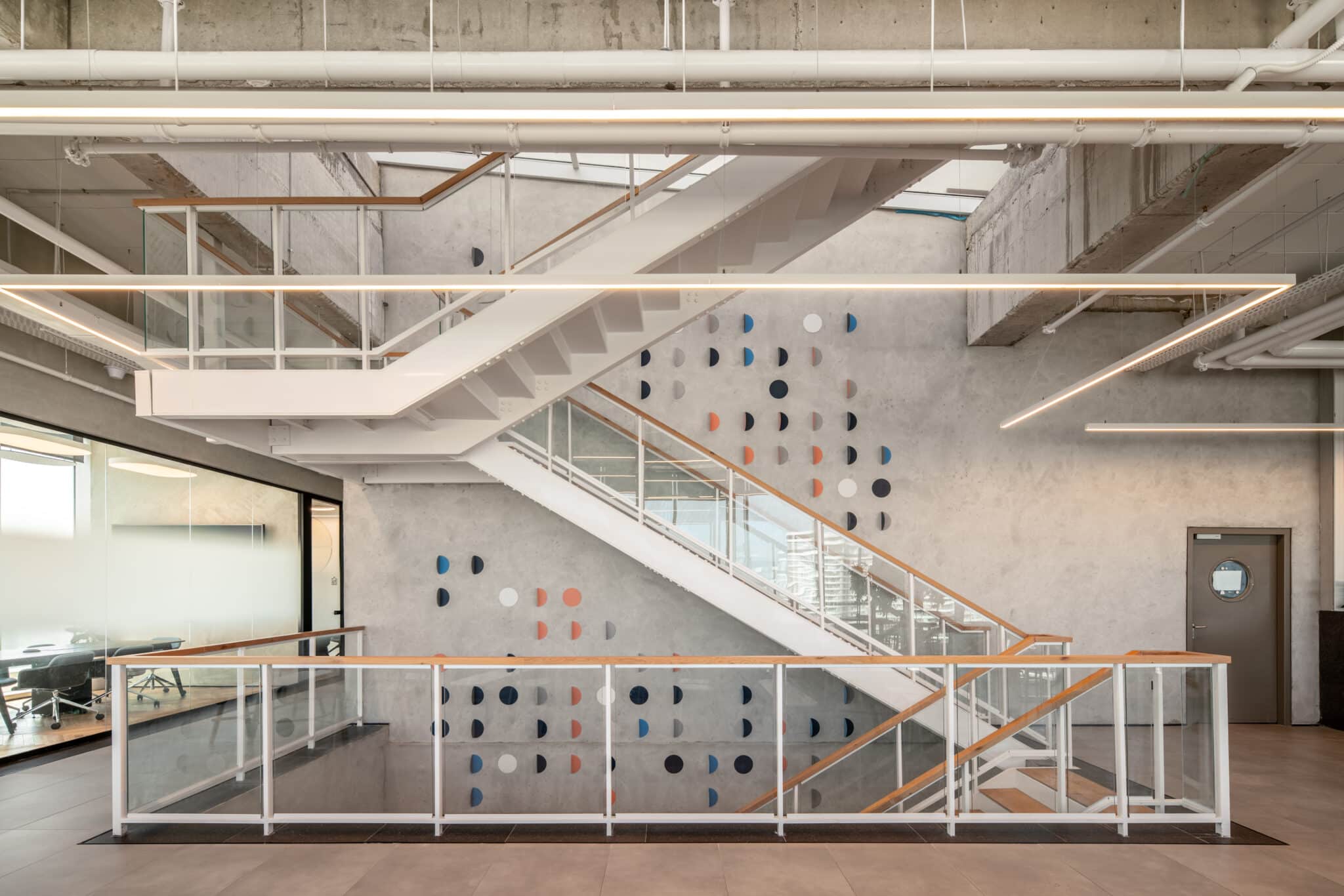 Coloured half-circle wall elements on a concrete stairwell wall