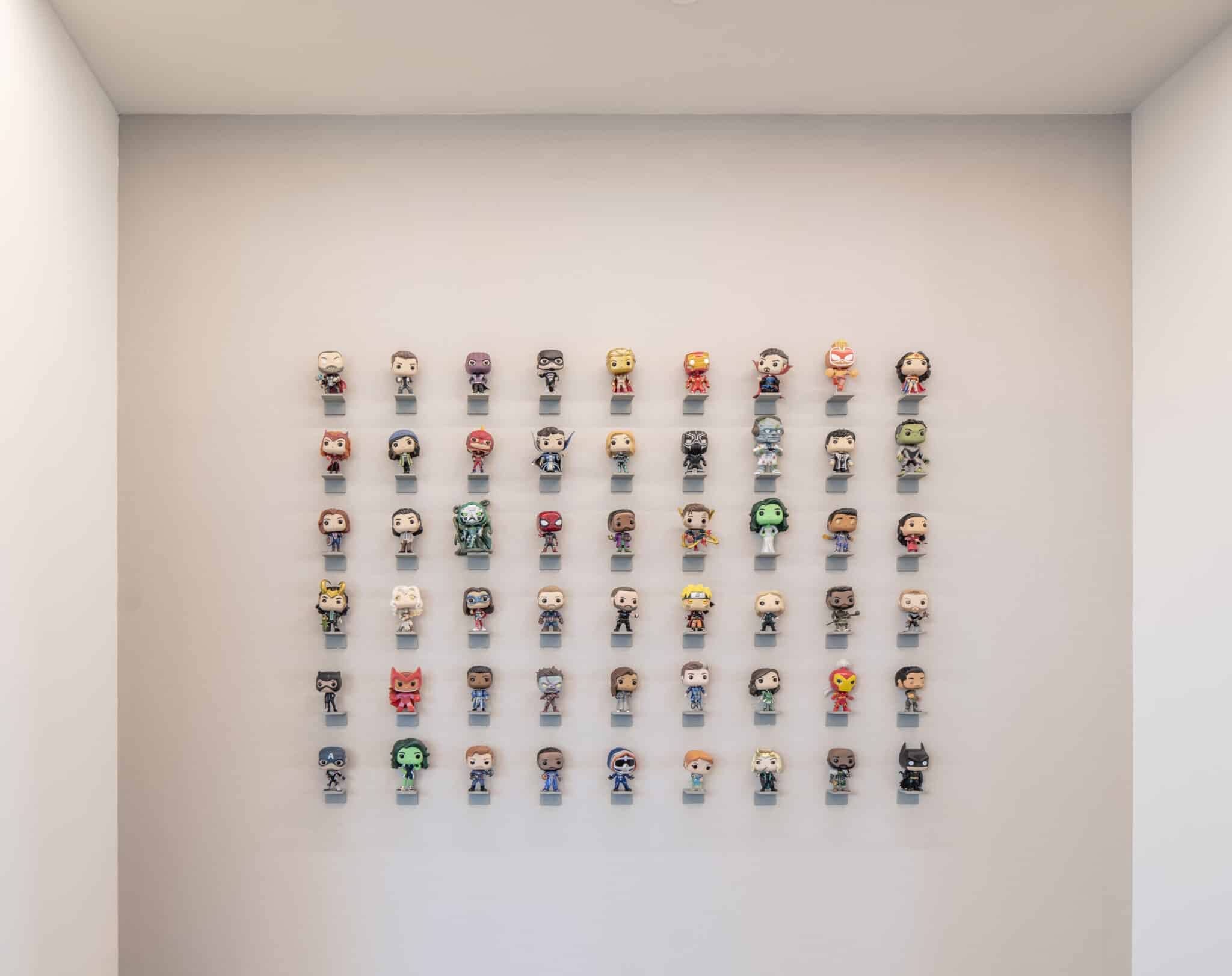 Wall grid of collectible figures on individual shelves