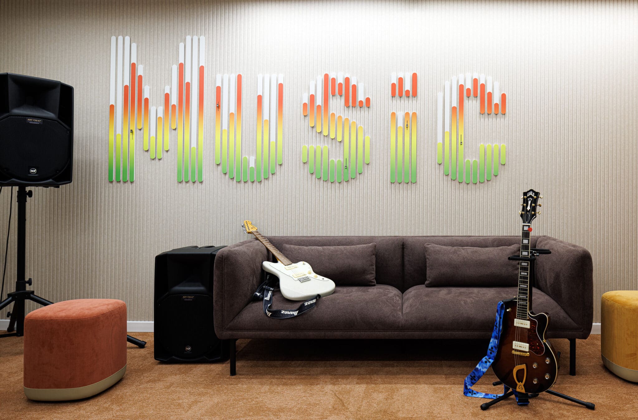 MUSIC 3D letters in a gradient of green to orange above a sofa