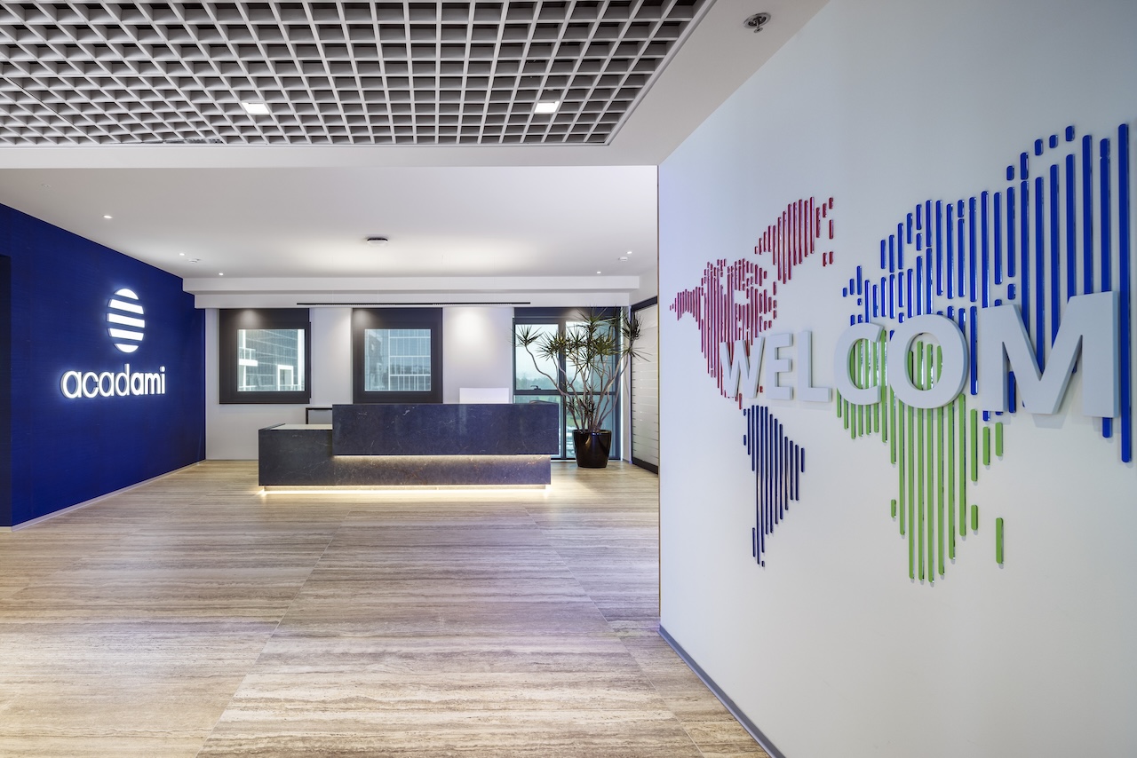 WELCOME 3D letters over a striped world map on a lobby wall