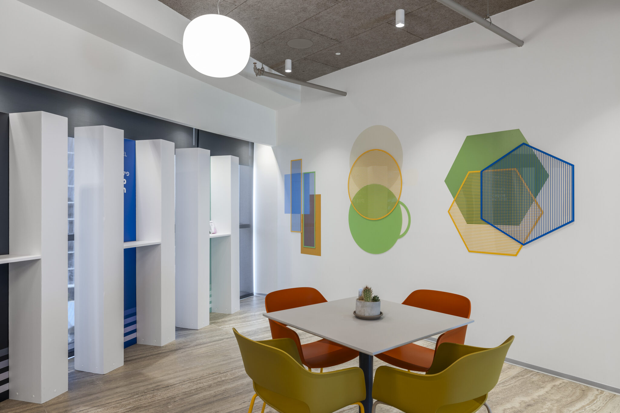 Overlapping geometric shapes wall graphic beside a dining table