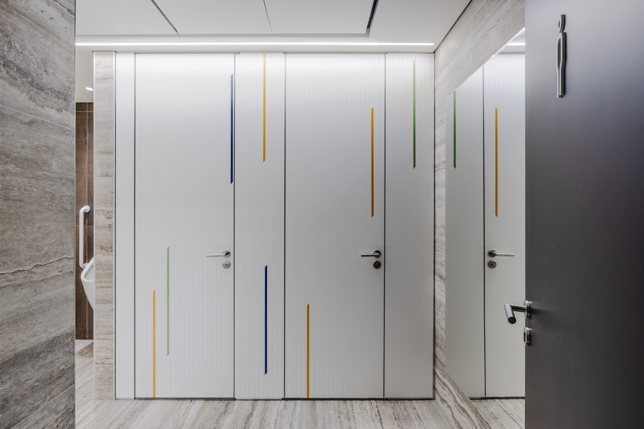 Coloured line graphics on restroom doors with a pictogram sign