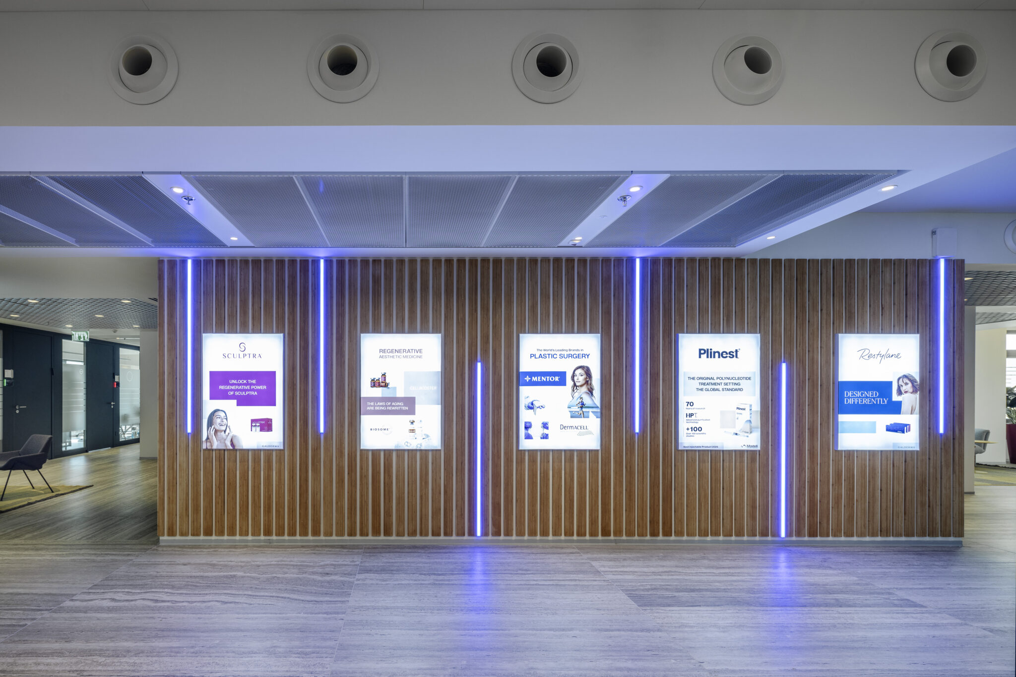 Five lightboxes with purple lit strips on a wood slat wall
