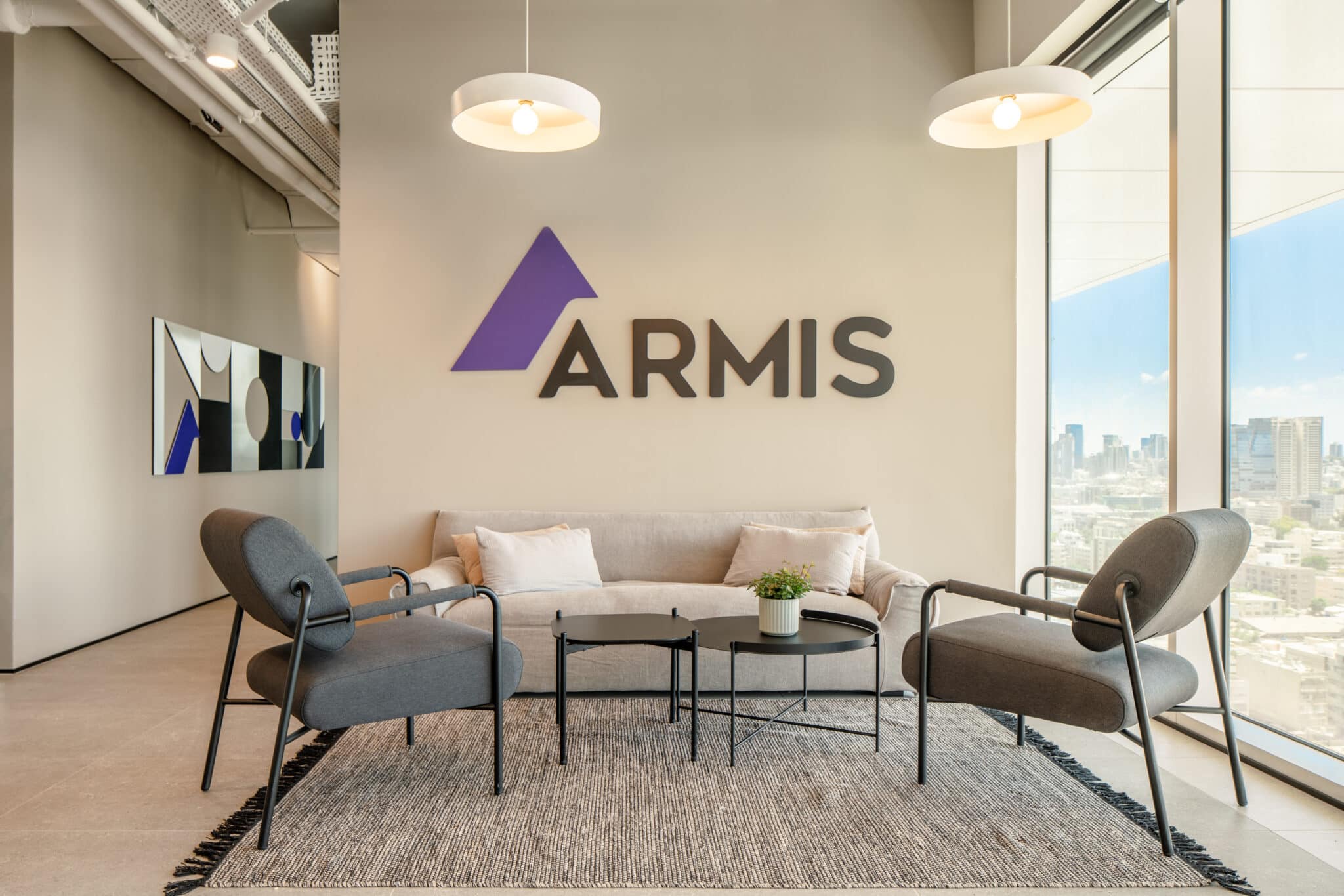 ARMIS 3D logo on a plaster wall above a lounge sofa
