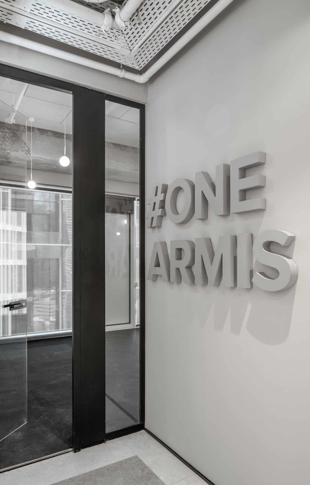 ONE ARMIS 3D letters in white on a corridor wall