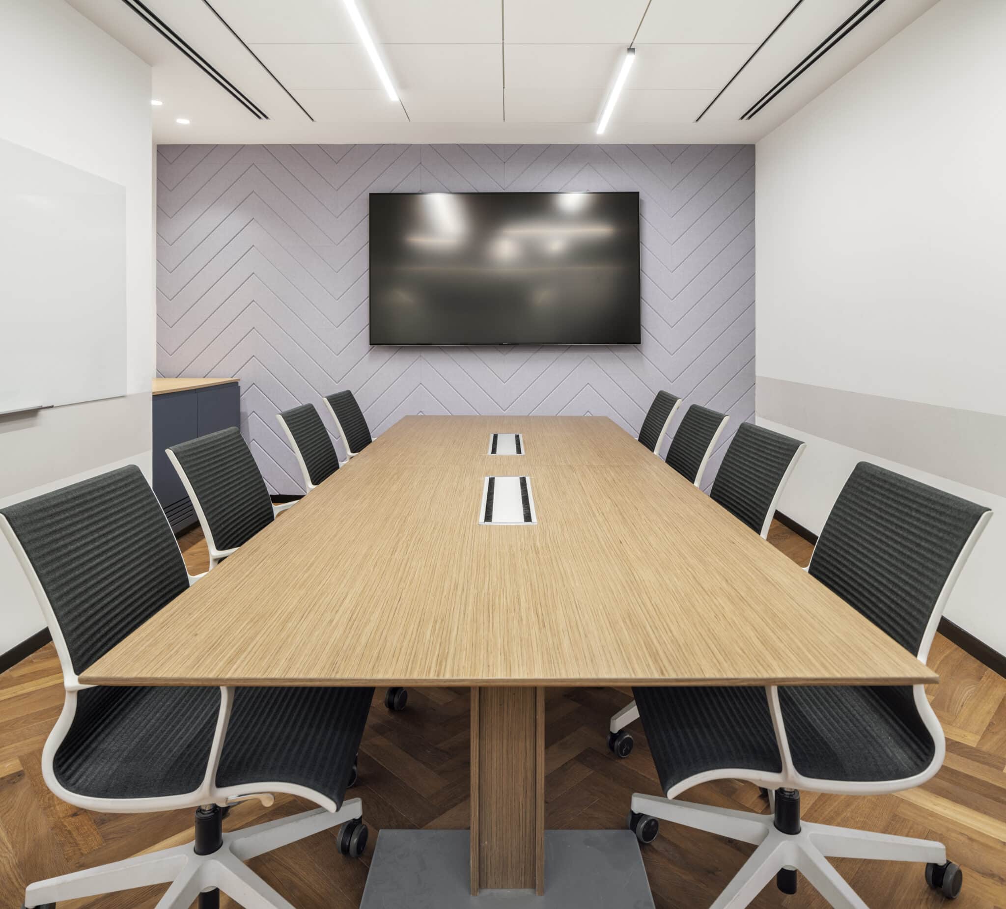 Herringbone relief panel wall behind a meeting room screen