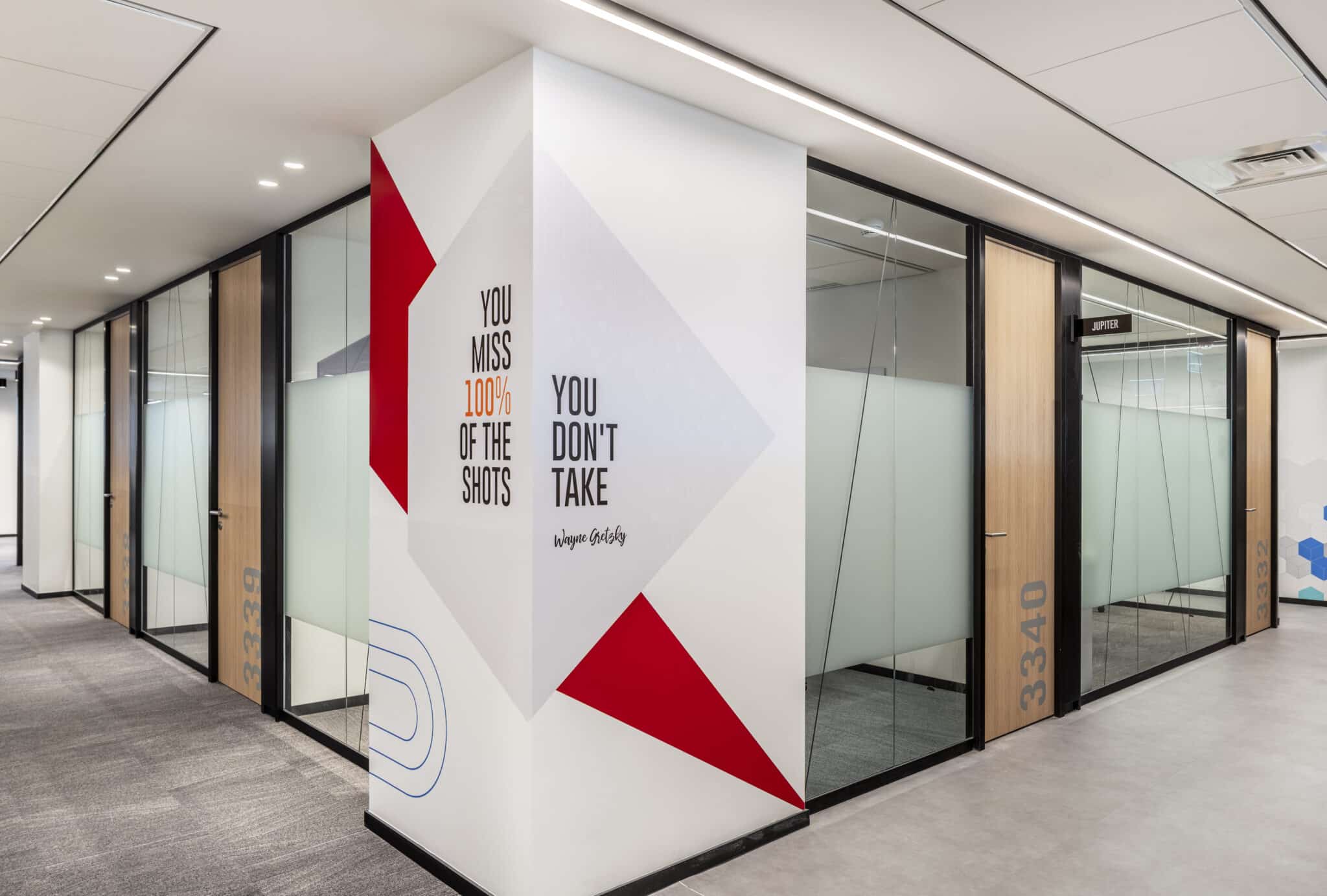Quote wall graphic on a corner column with room number signage
