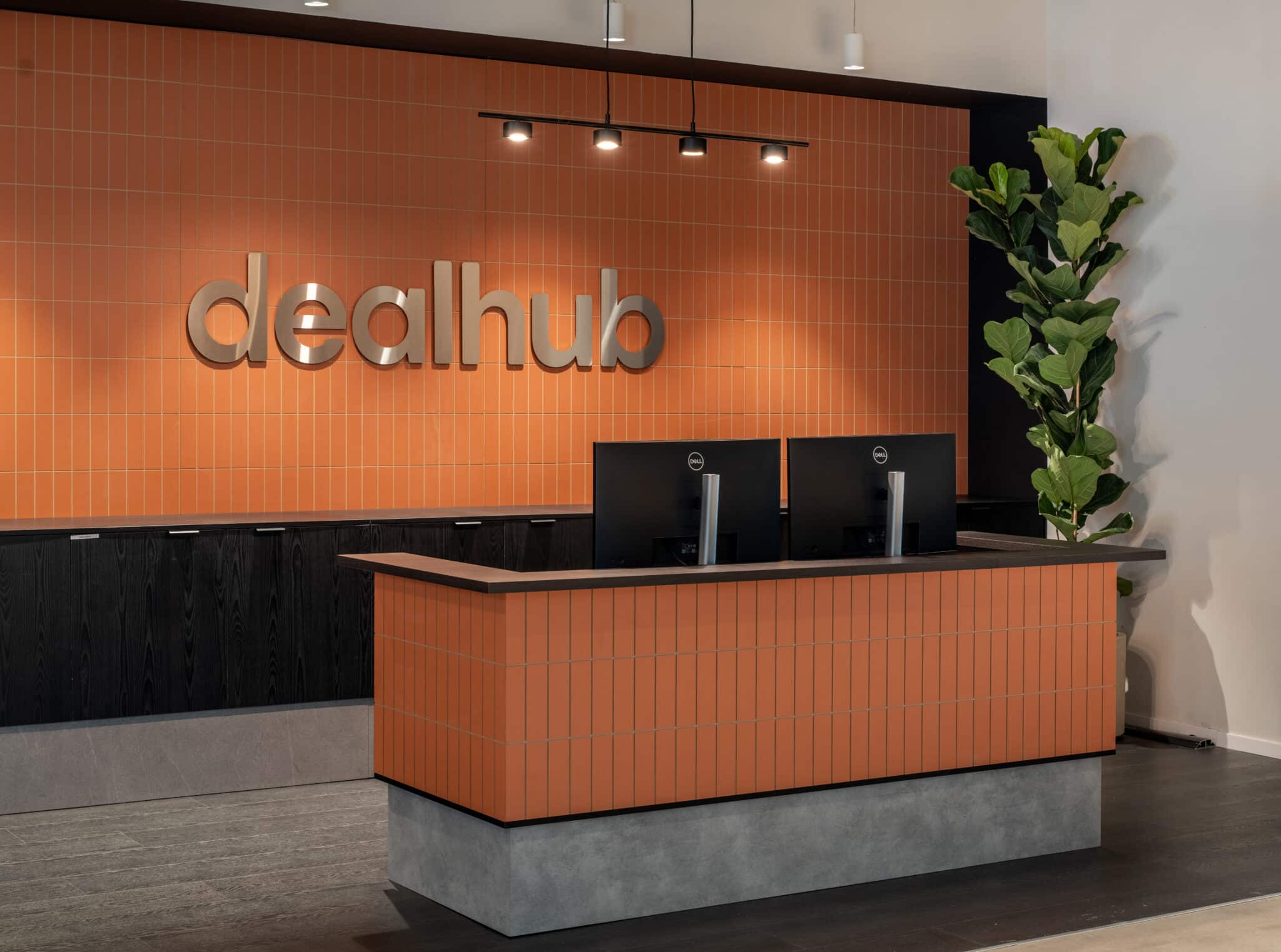 dealhub 3D logo on an orange tiled reception wall