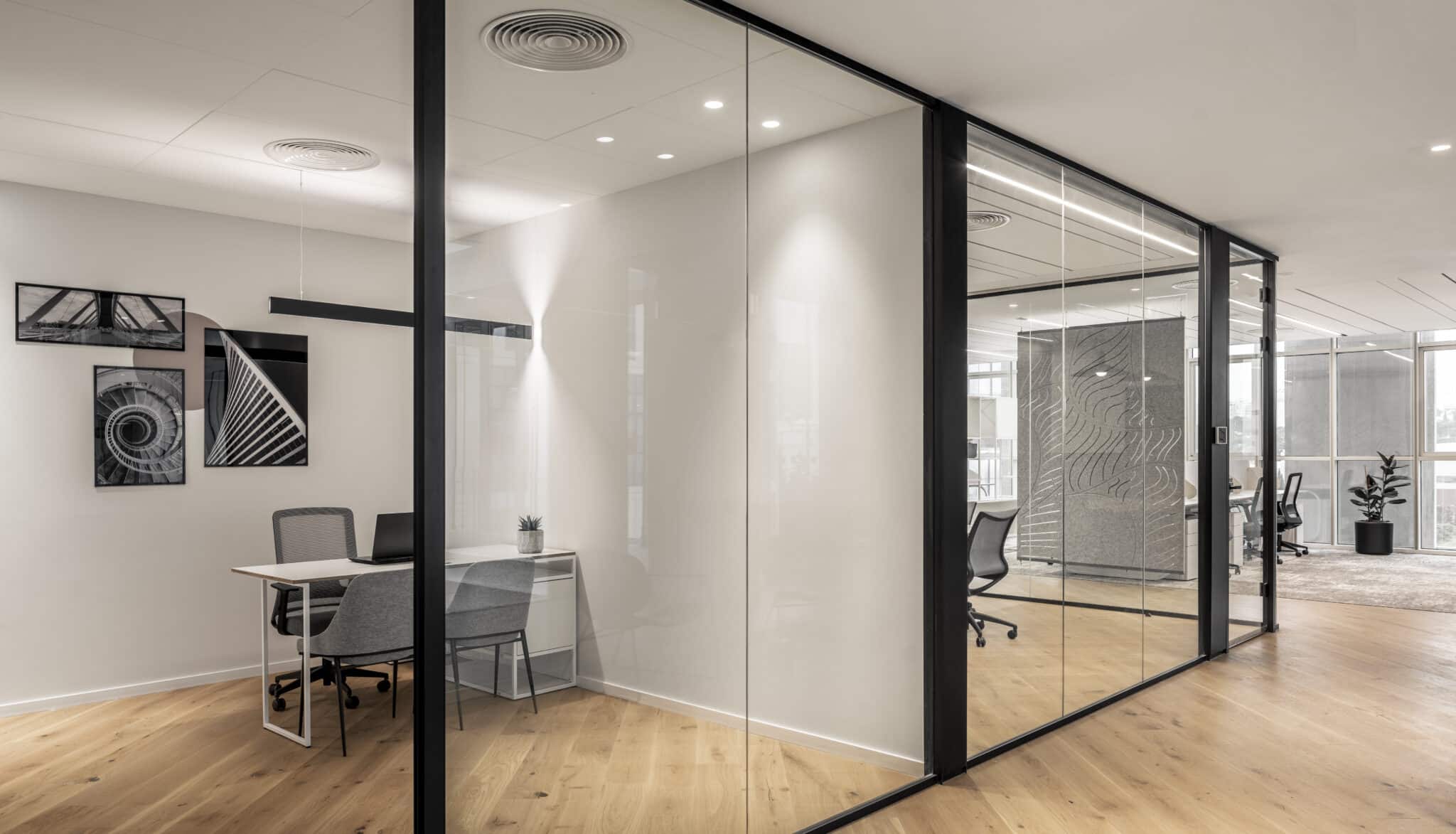 Framed pictures on the wall of a glass-fronted office