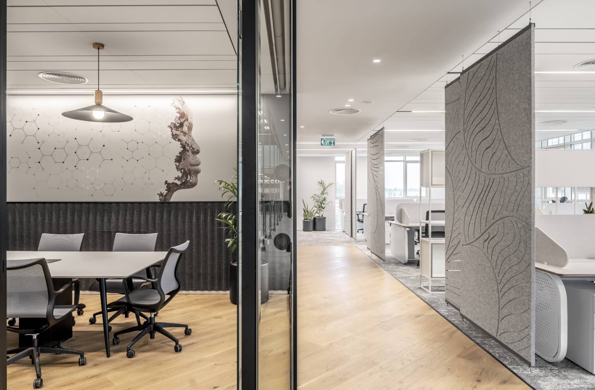 Hexagon molecule wall graphic in a meeting room beside a carved felt screen