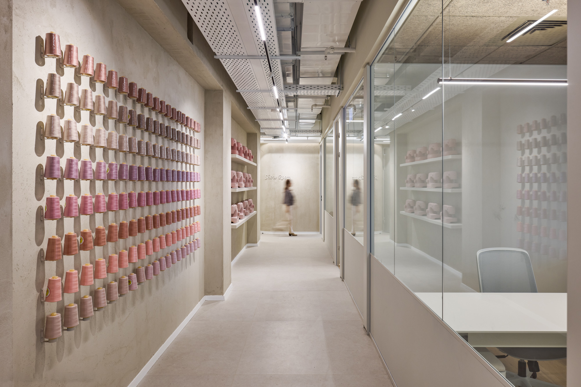 Wall of pink thread spools mounted as a 3D display