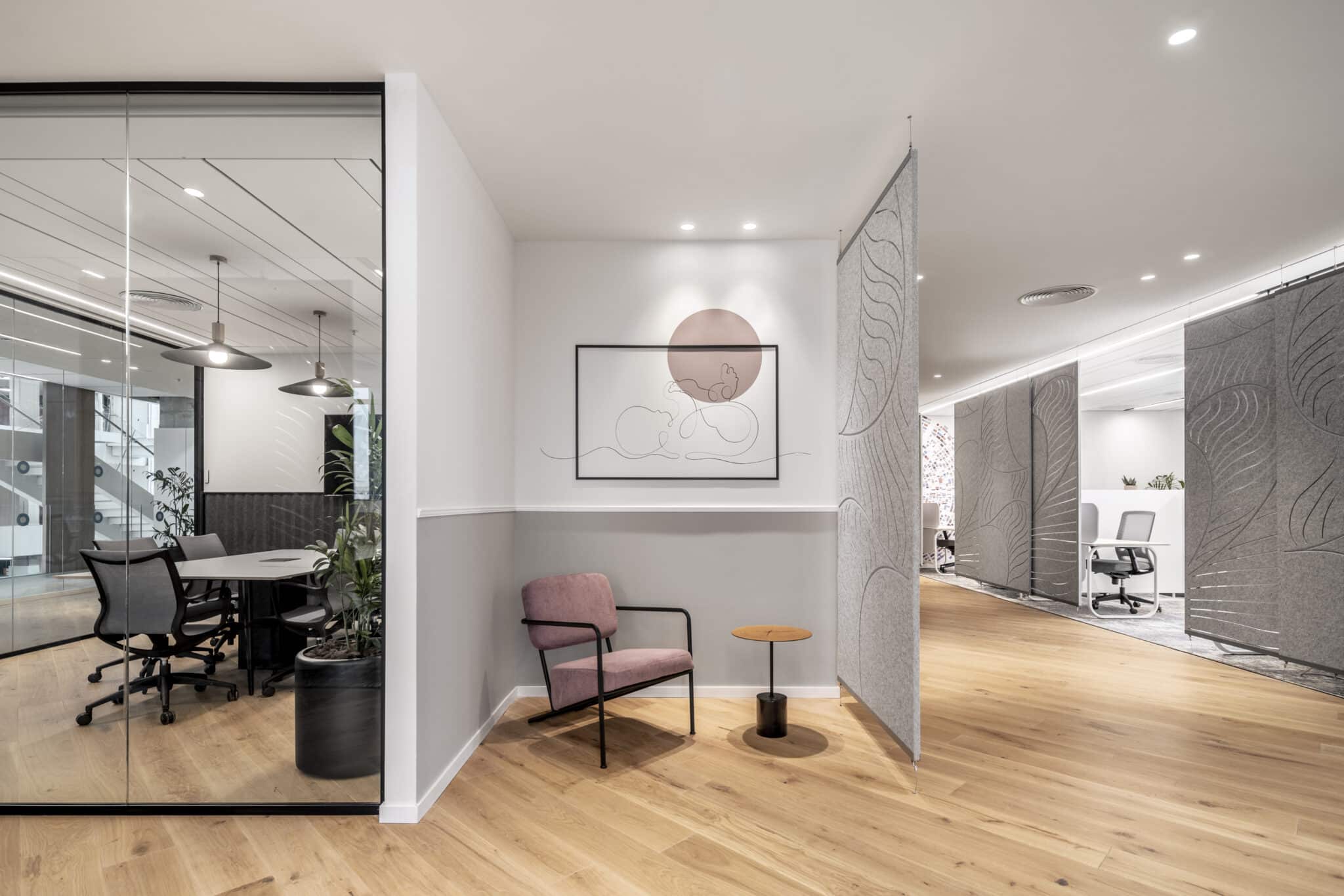 Framed photographs on the wall of a glass-fronted office