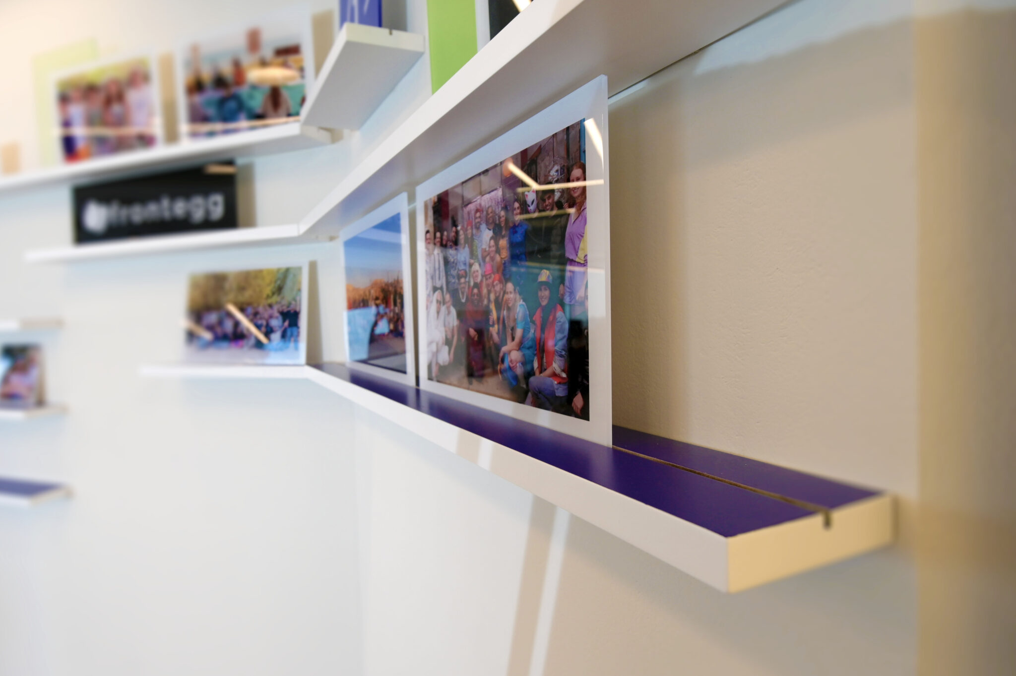 White picture ledges holding team photos on an office wall