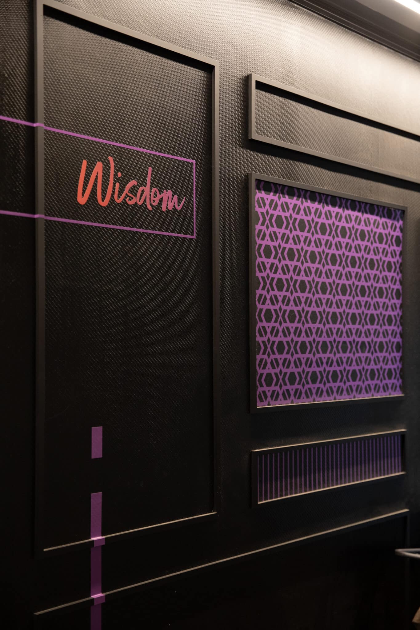 Framed line artwork on a dark panelled wall with neon lettering