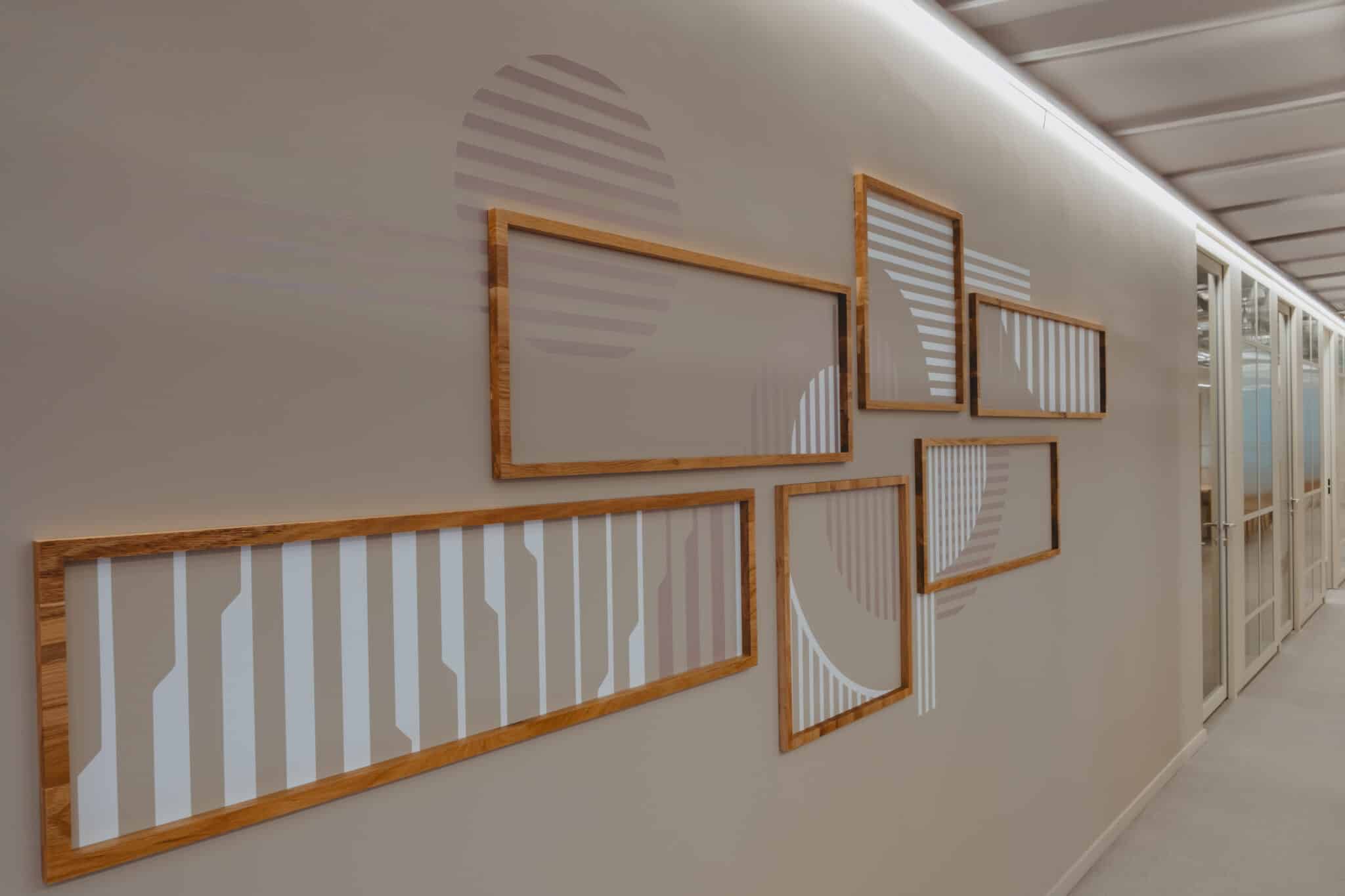 Wood-framed panels with printed line patterns on a corridor wall