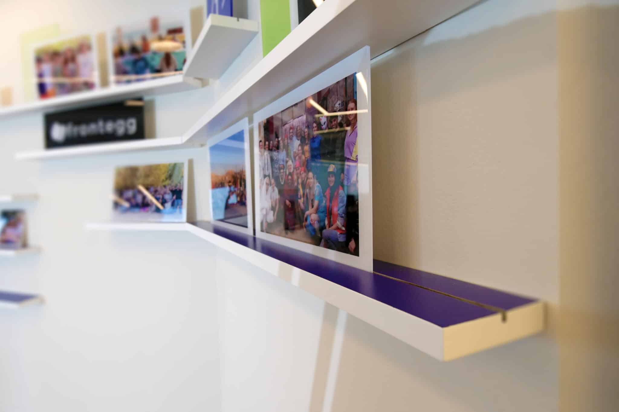 Photo display shelves with a small frontegg logo sign