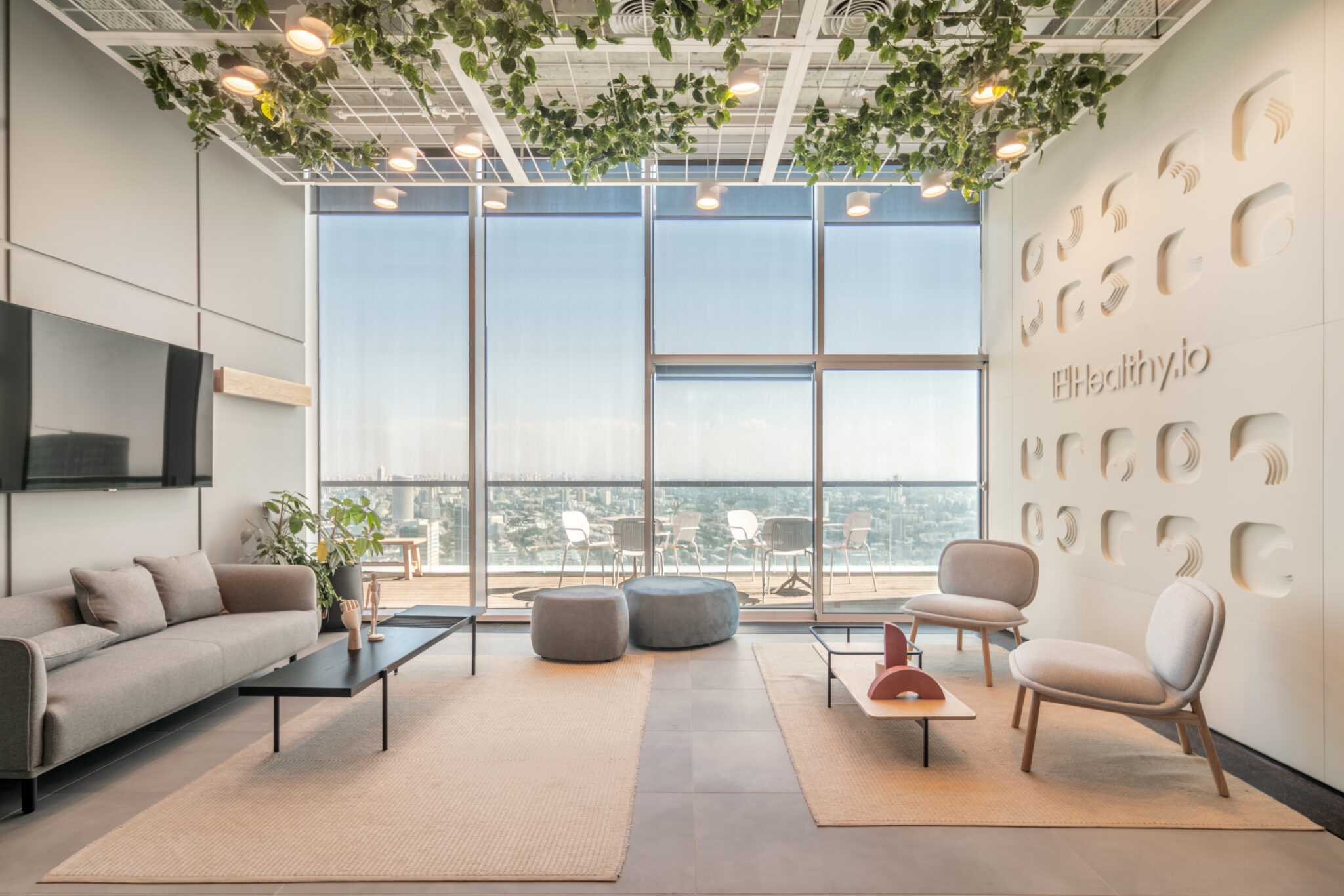 Healthy.io logo on a relief wall of rounded recessed shapes in a lounge