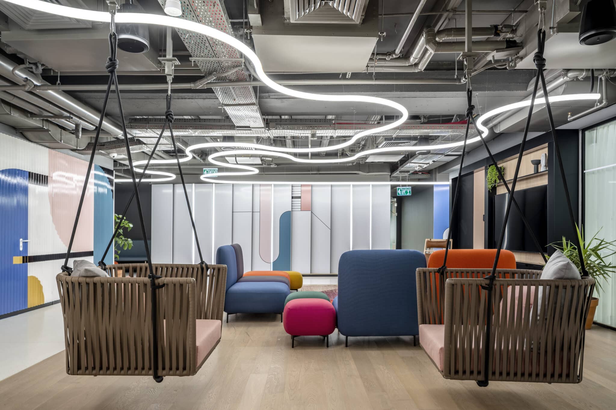 Coloured wall graphics around a lounge with hanging swing seats