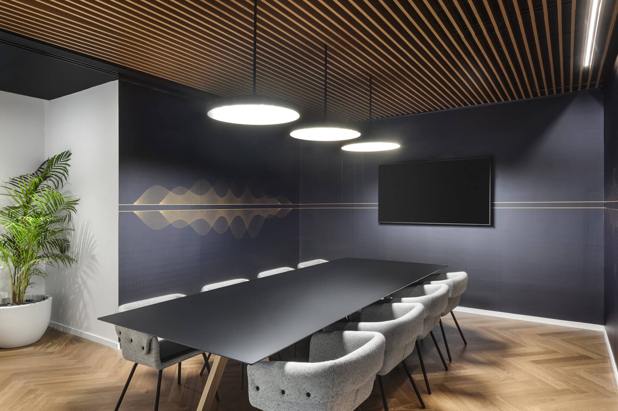 Gold sound-wave line graphic on a dark blue meeting room wall