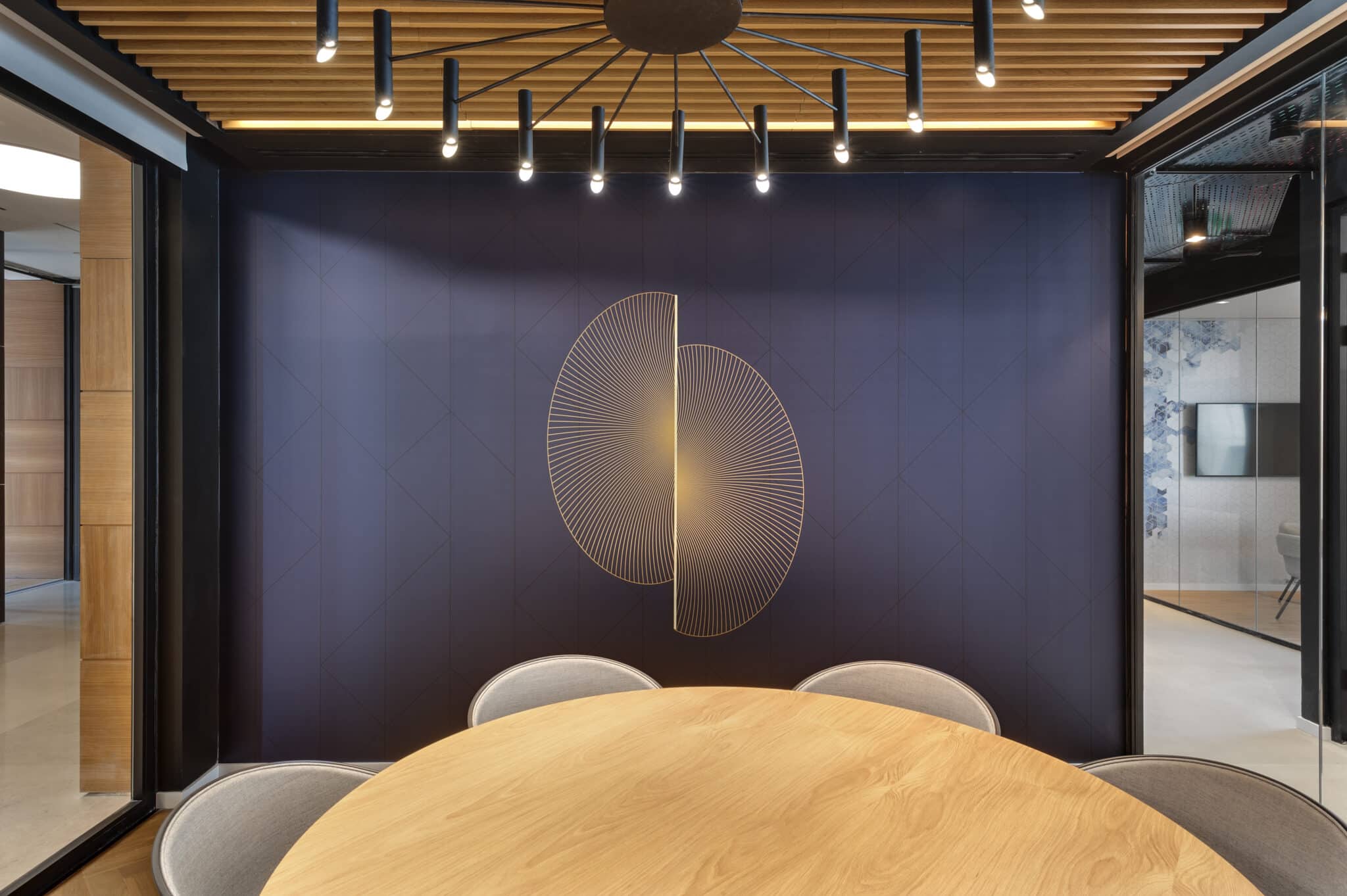 Gold fan-shaped line graphic on a navy meeting room wall