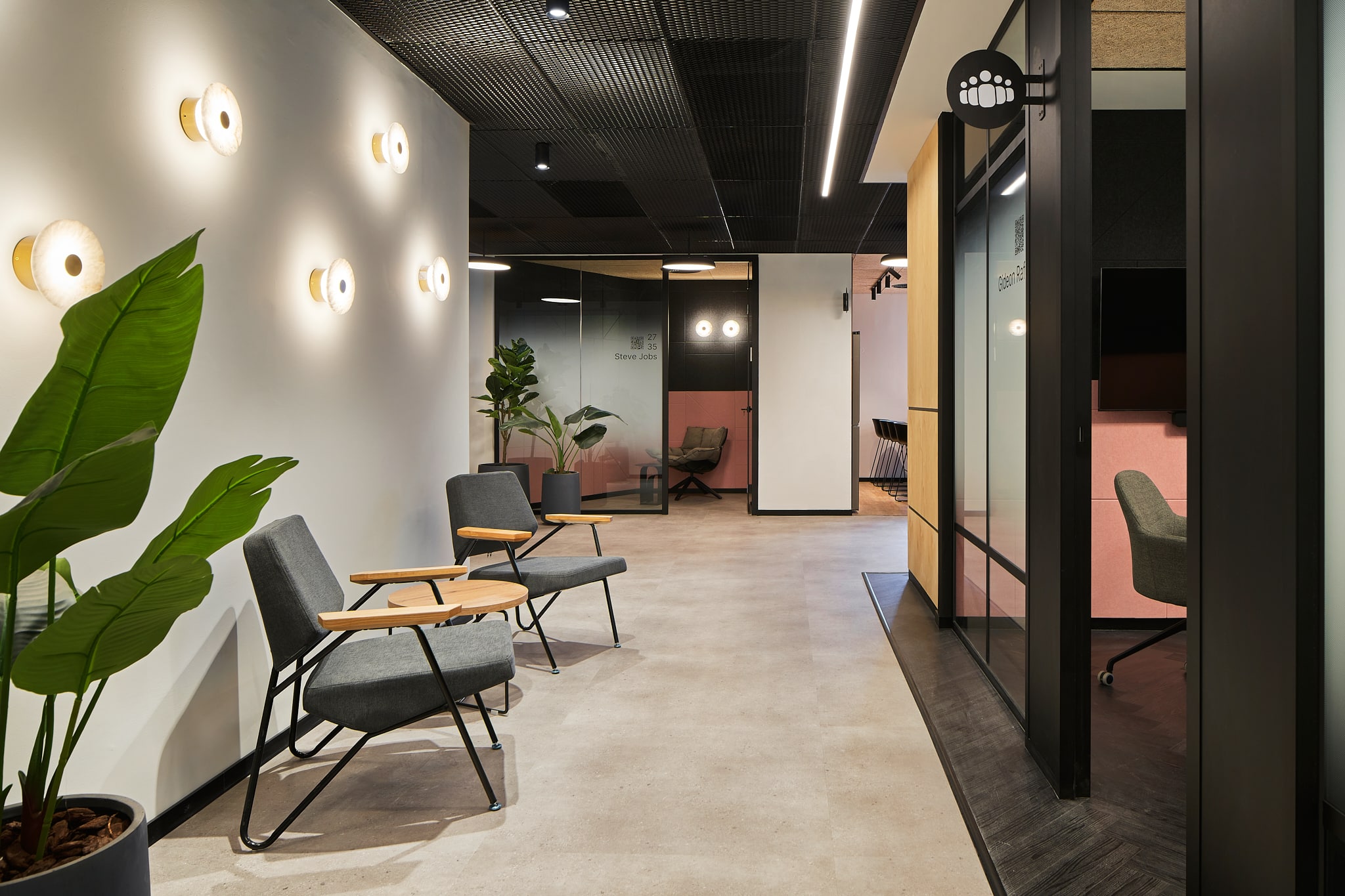 Lounge beside glass rooms with printed icons and room names