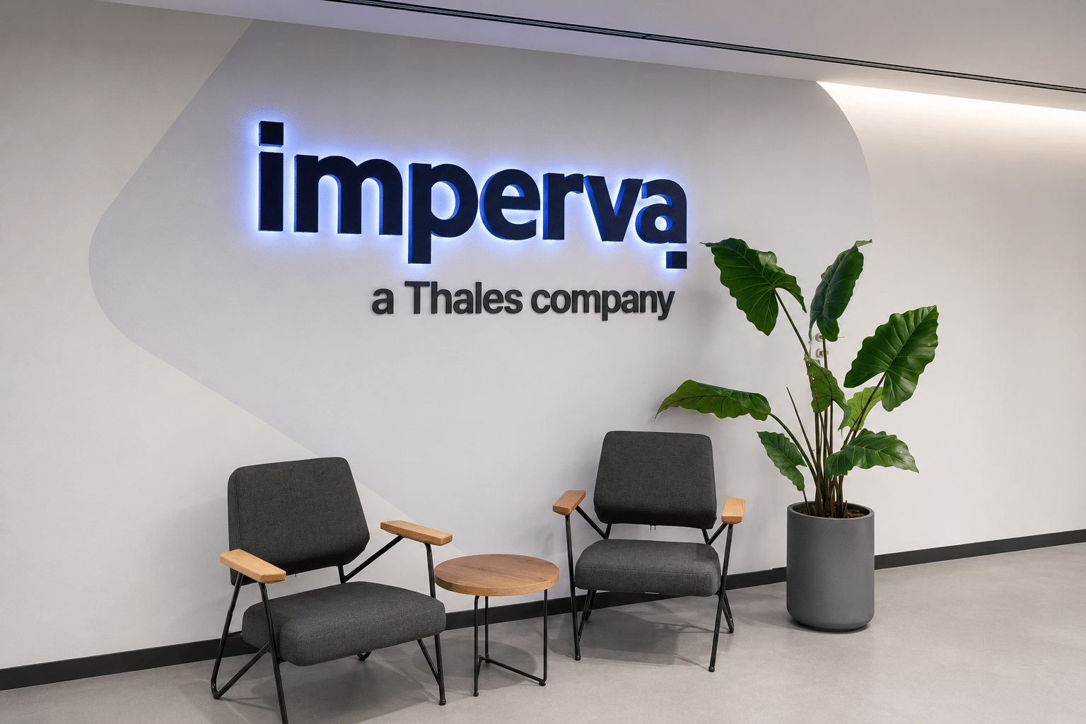 Backlit imperva logo on a curved reception wall