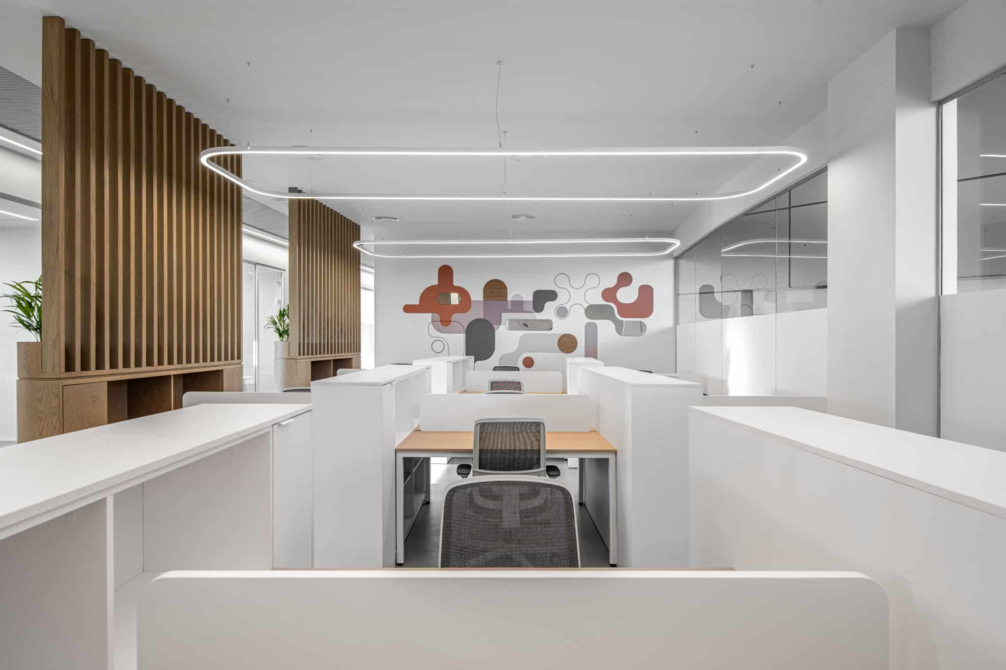 Rounded molecule wall graphic in orange and grey behind office desks