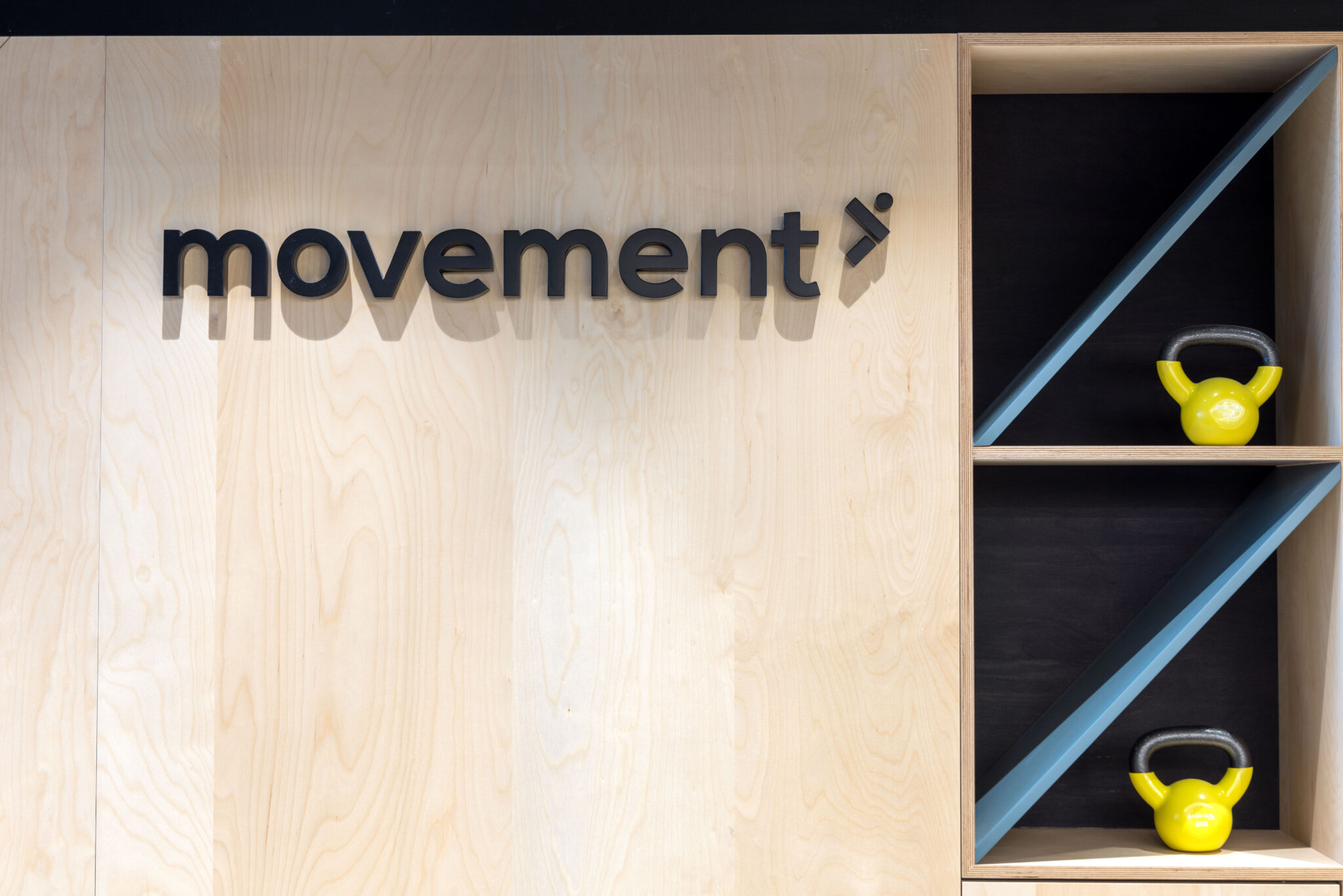 movement 3D logo letters on a plywood gym wall