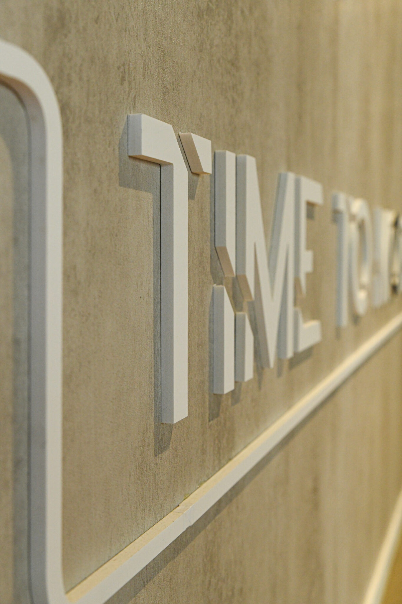 Close-up of white 3D letters on a concrete wall