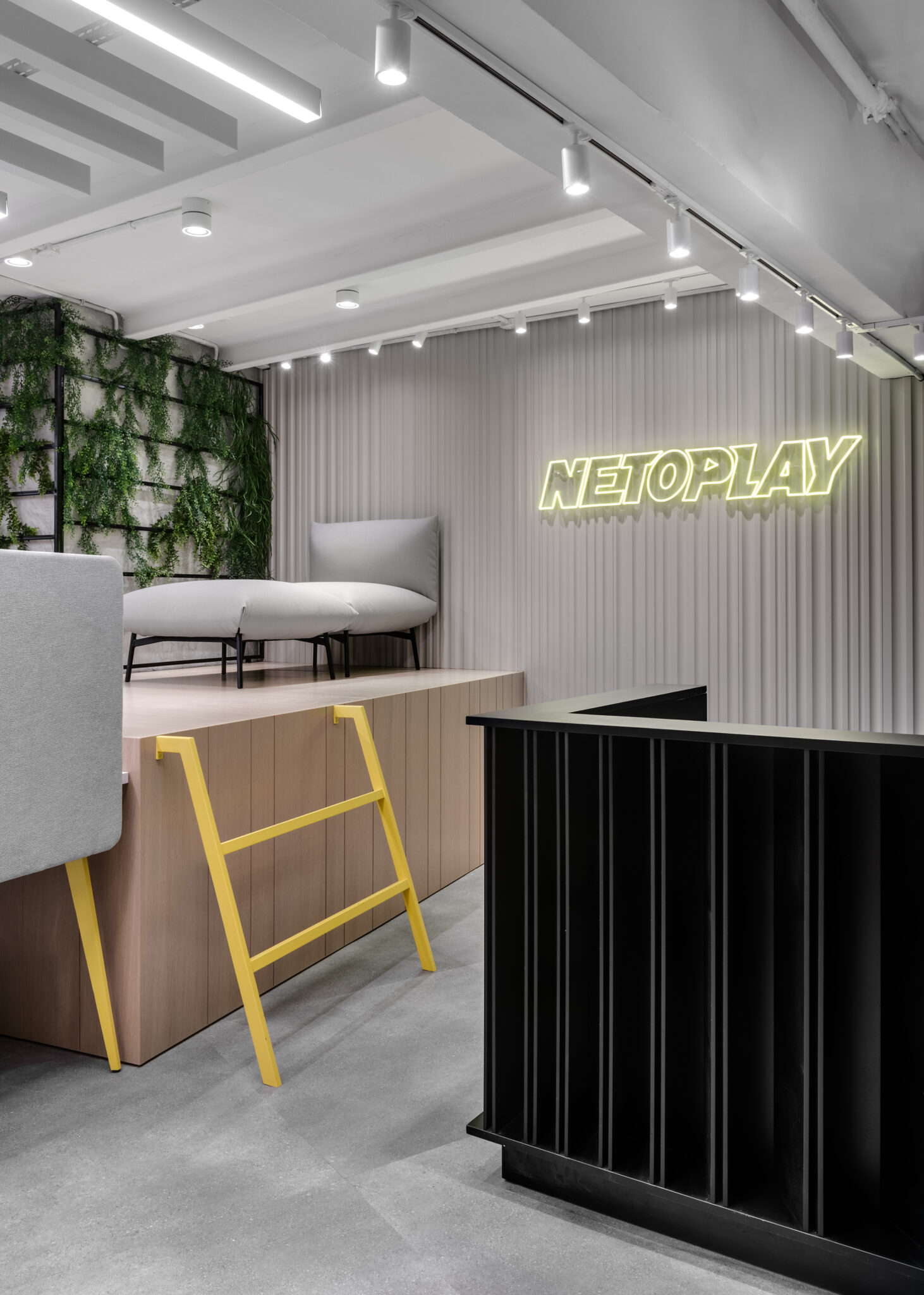 NETOPLAY neon lit logo on a fluted wall above reception