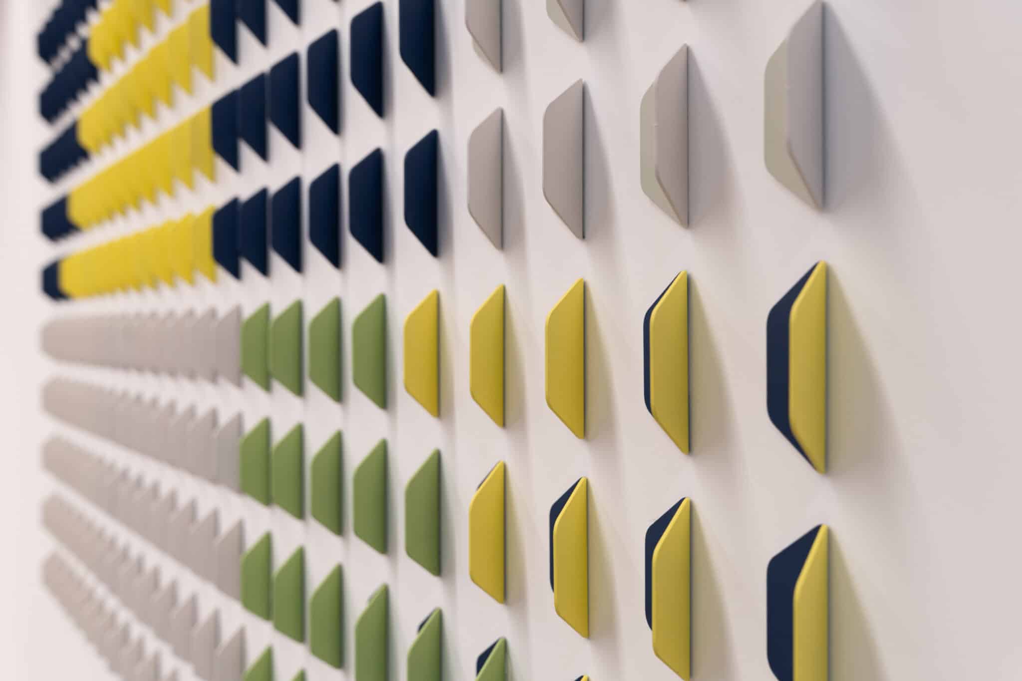 Close-up of folded 3D wall tiles in yellow, navy and green