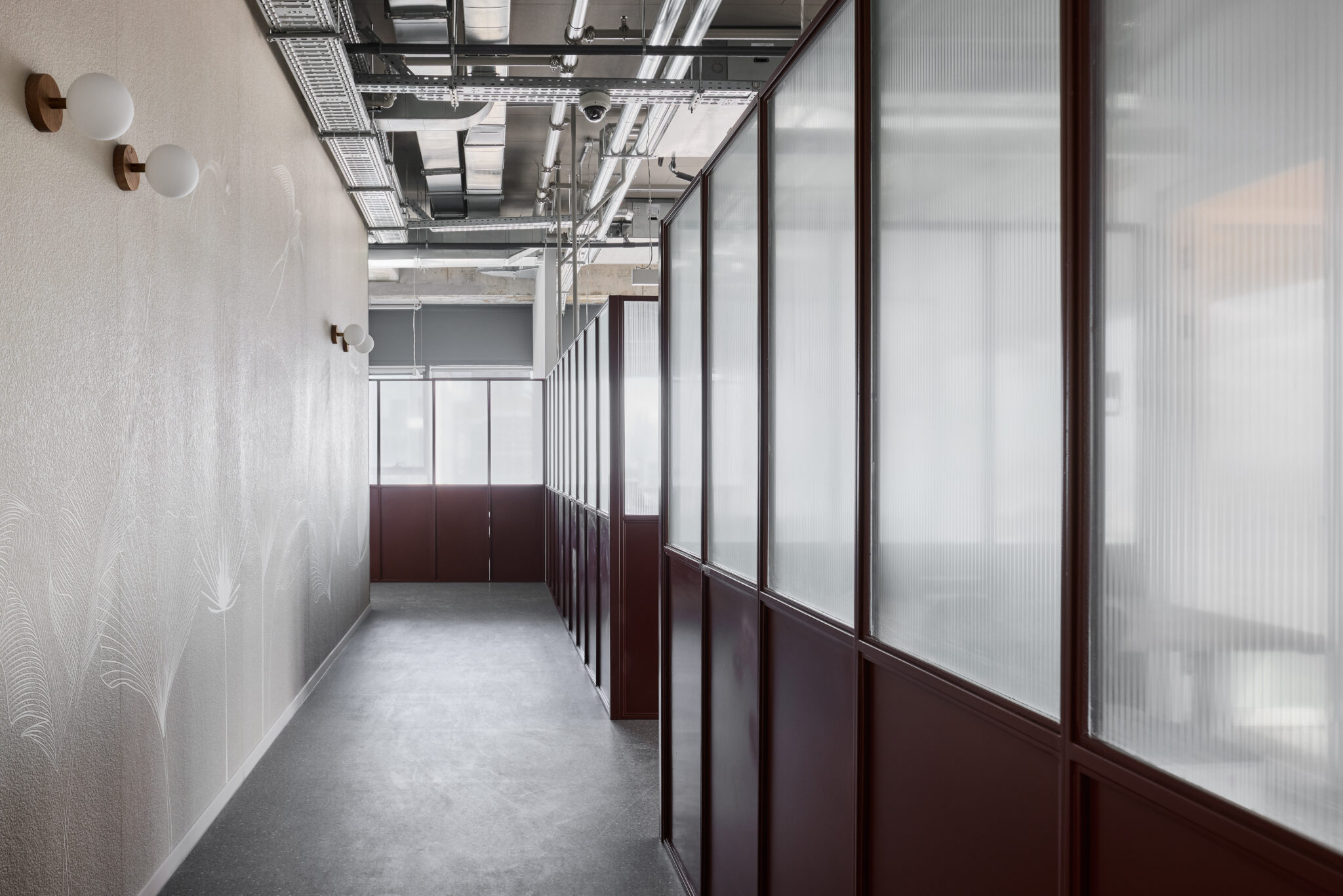 Corridor wall with leaf line graphic beside fluted glass fronts