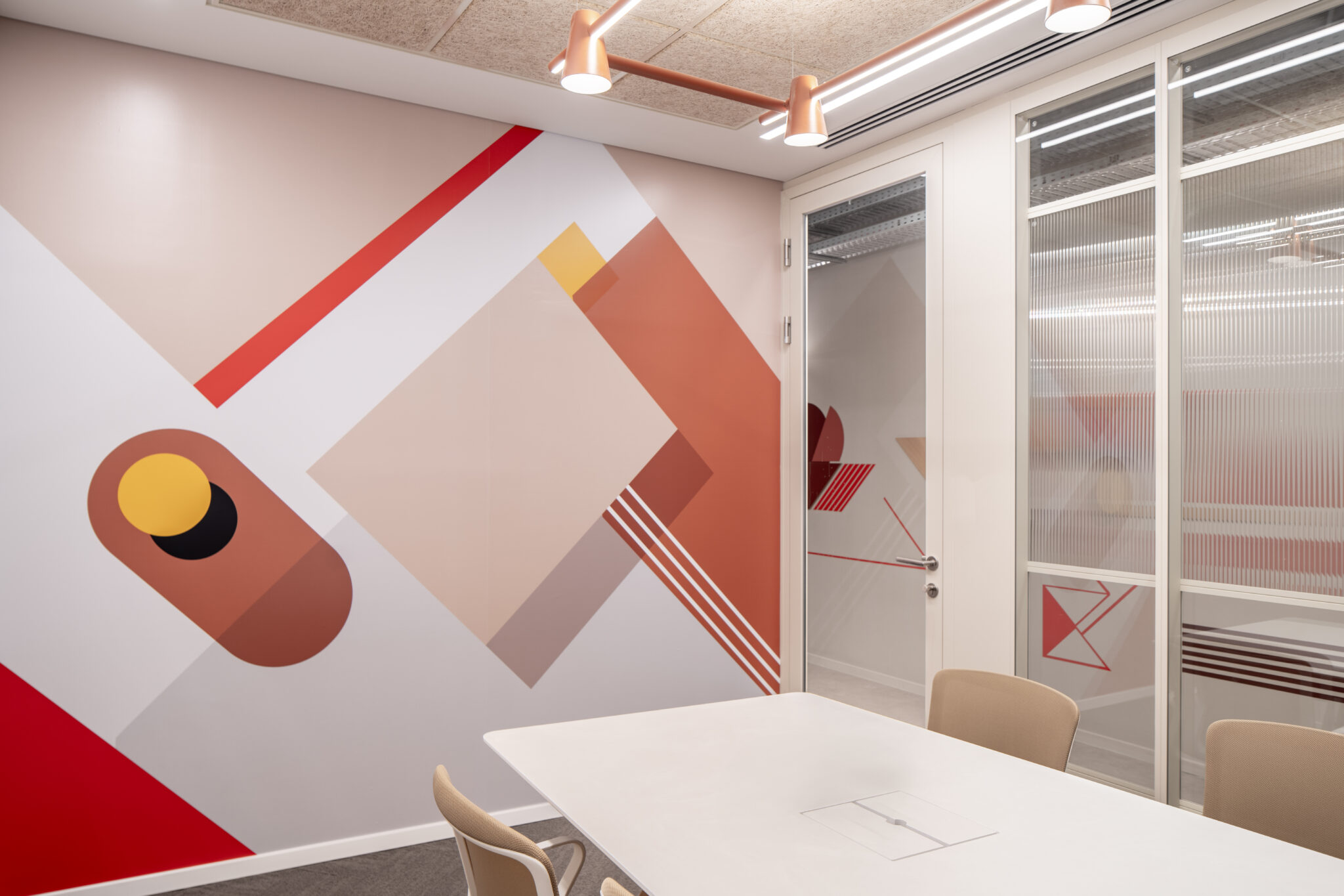 Large geometric wall graphic and printed fluted glass in a meeting room