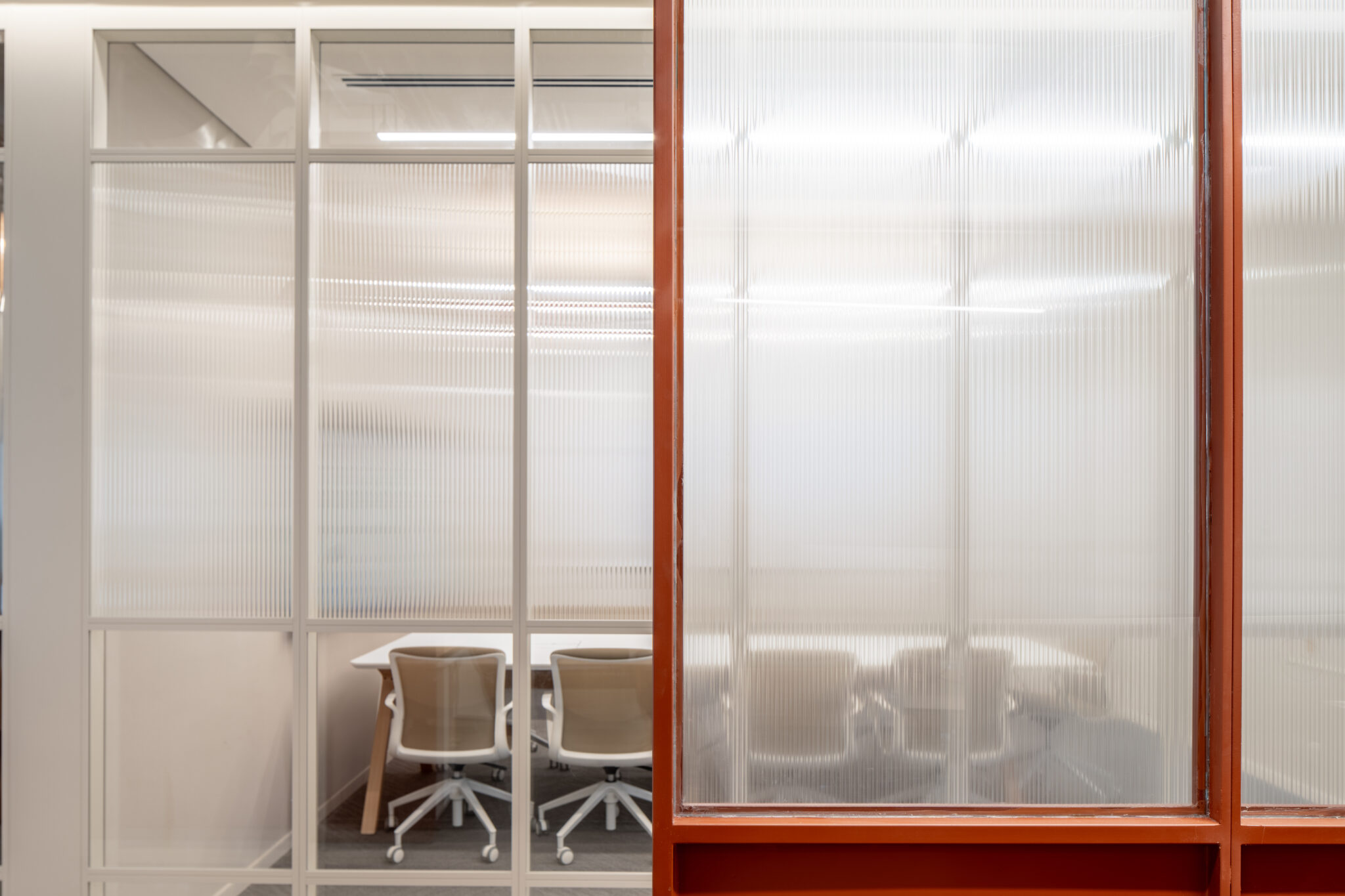 Fluted glass partitions in white and orange frames