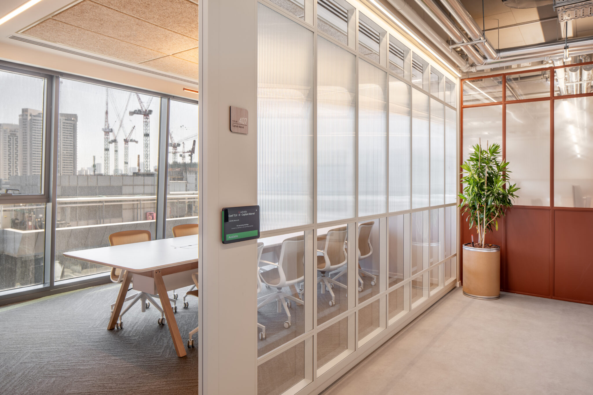 Fluted glass meeting room wall with a room sign in a corridor