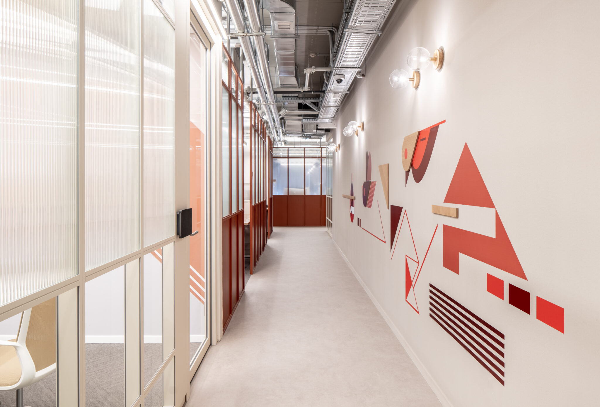 Red and grey geometric wall graphic along a corridor