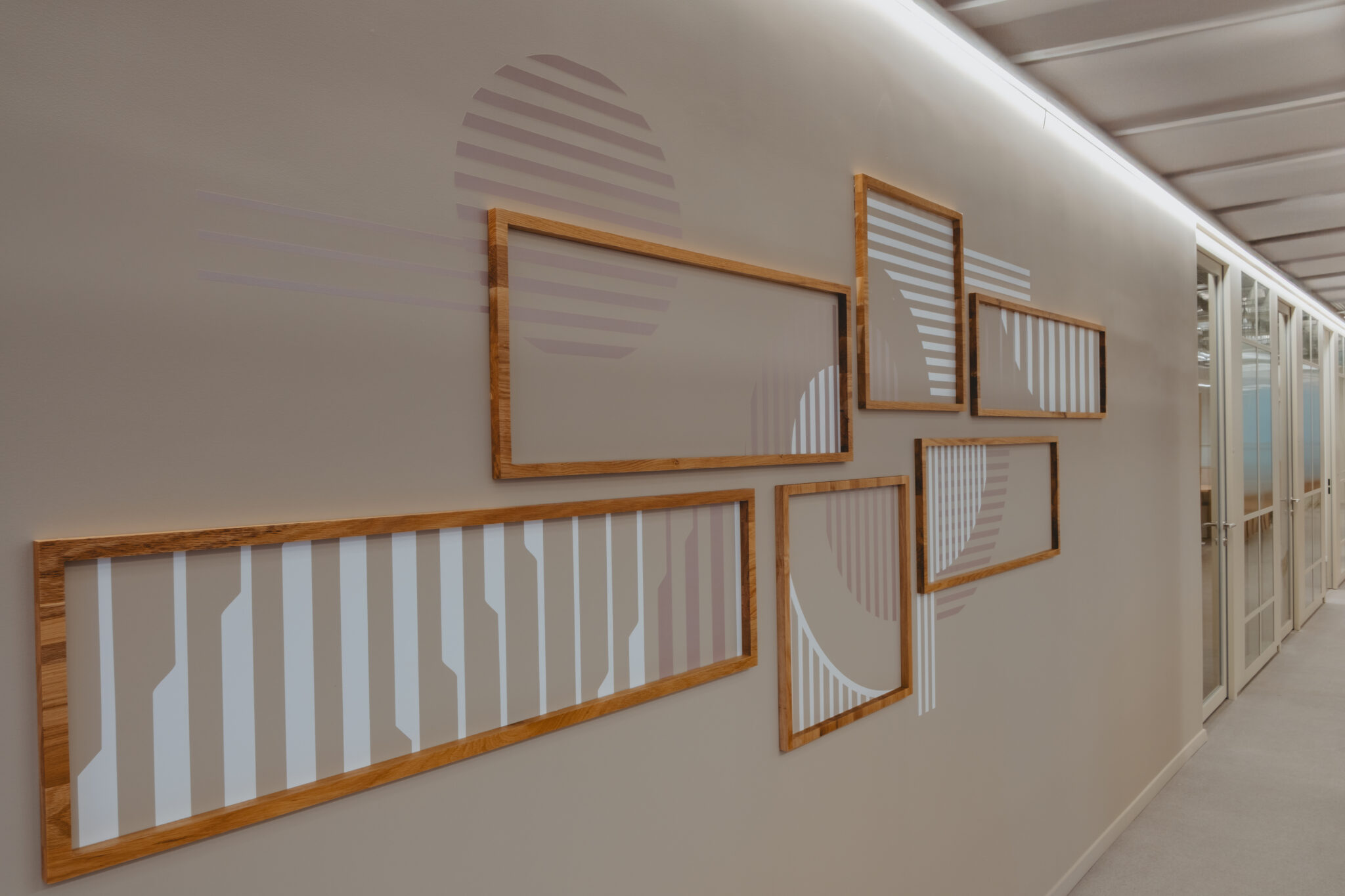 Wood-framed panels with printed line patterns on a corridor wall