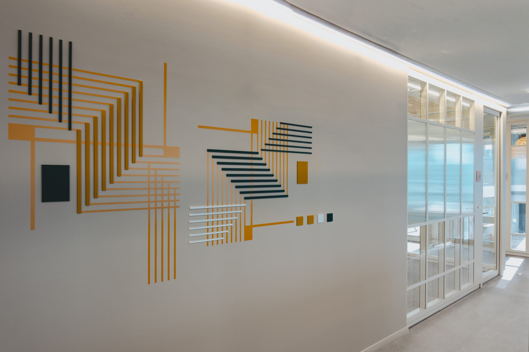 Orange and black line wall graphic beside a glass wall