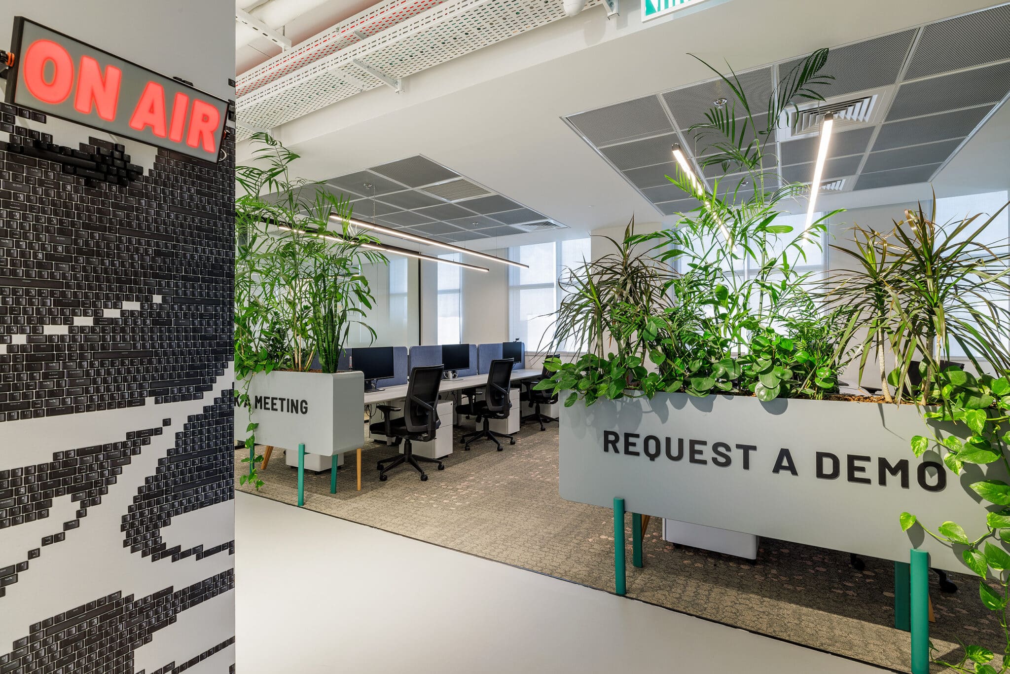 ON AIR neon sign and REQUEST A DEMO lettering in an open office