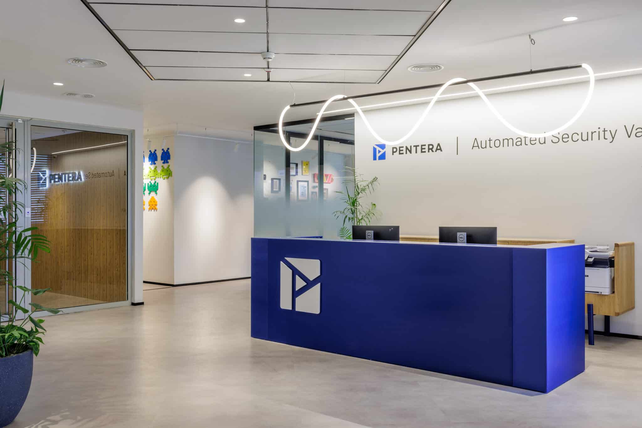 Blue reception desk with the PENTERA logo under a wavy neon line