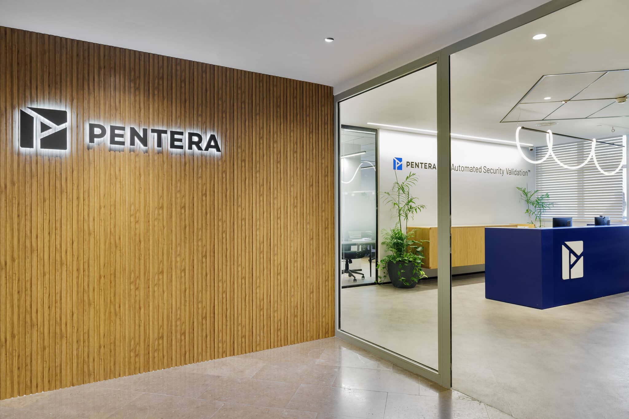 Backlit PENTERA logo on a wood slat wall at the entrance