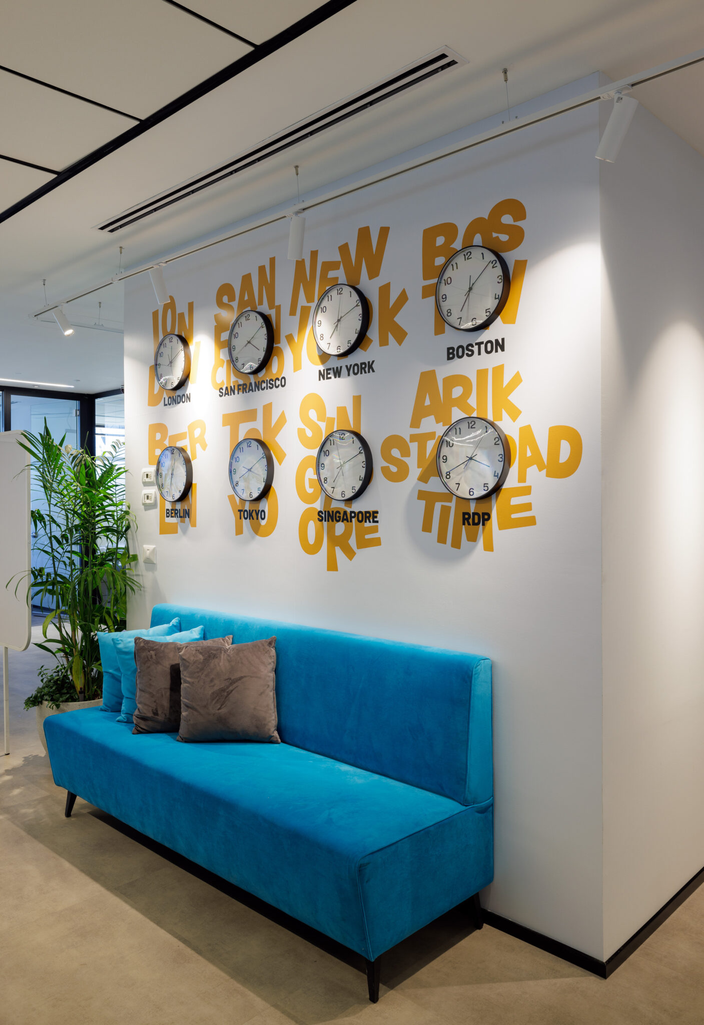 3D city name letters and world clocks on a lounge wall